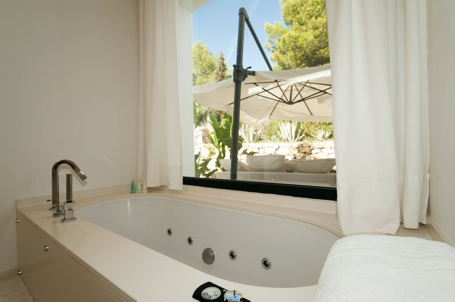 En-suite bathroom with a jacuzzi tub set beneath a garden-facing window