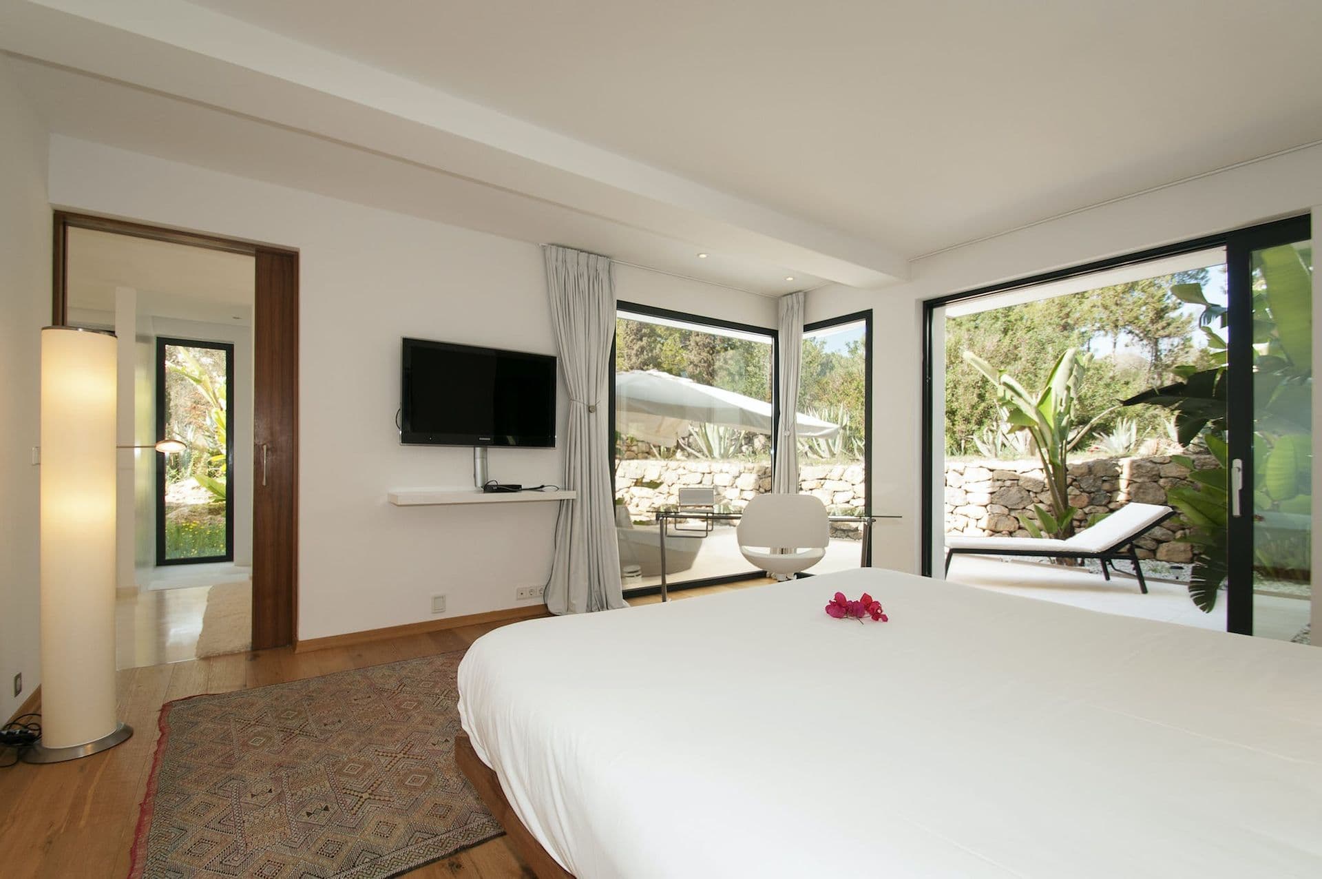 Bedroom with open-plan en-suite bathroom and views over the pine hillside