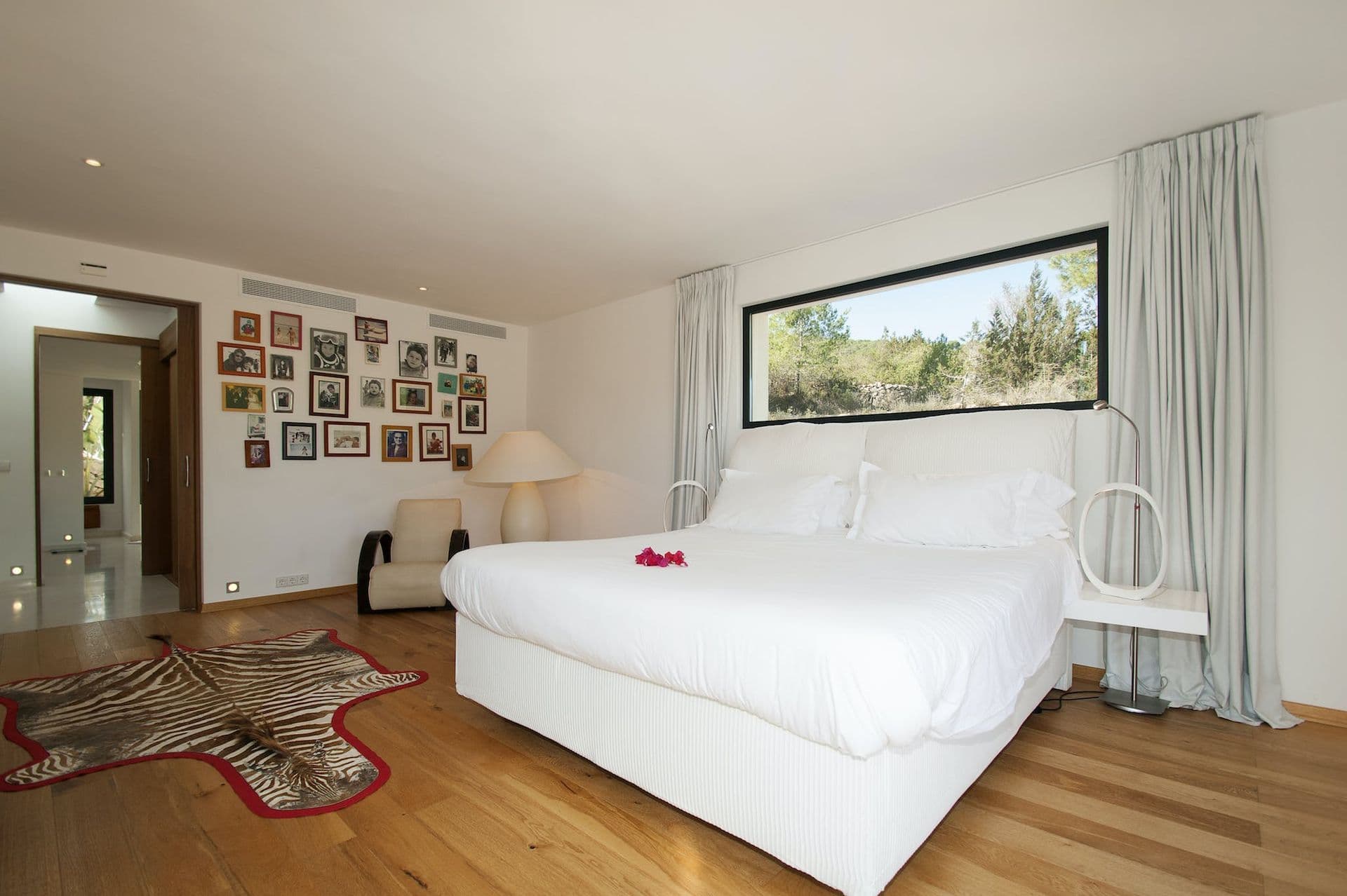 Bedroom with zebra-print rug, family photographs and garden outlook