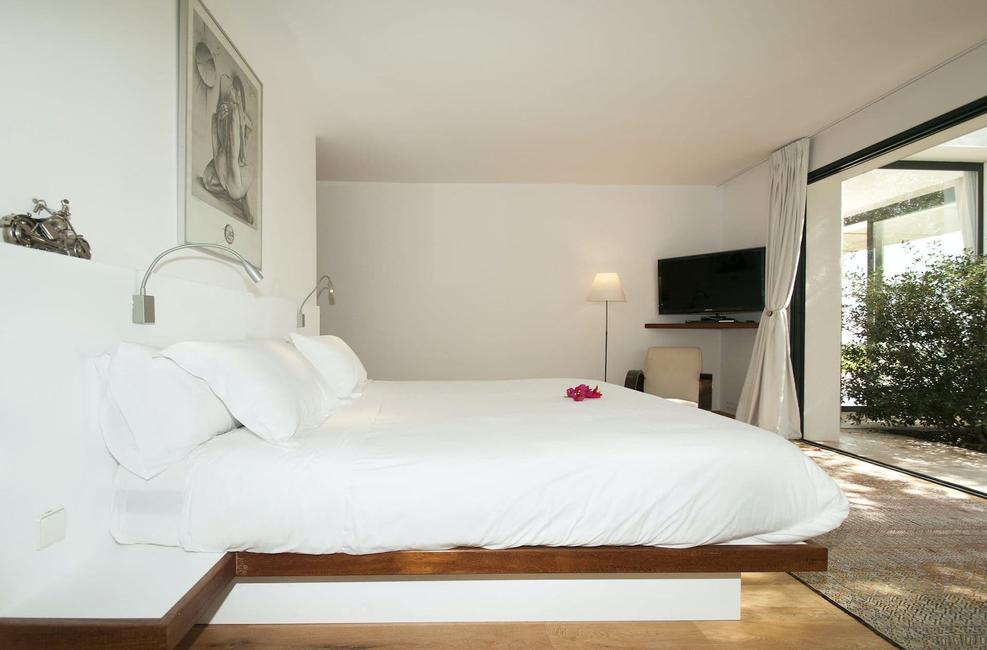 Lower-level bedroom with dark wood platform bed and artwork above the headboard