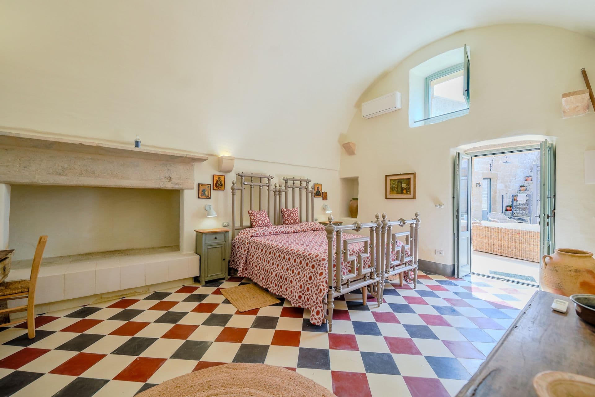 Bedroom with fireplace and checkered floor at Puglian Farmhouse