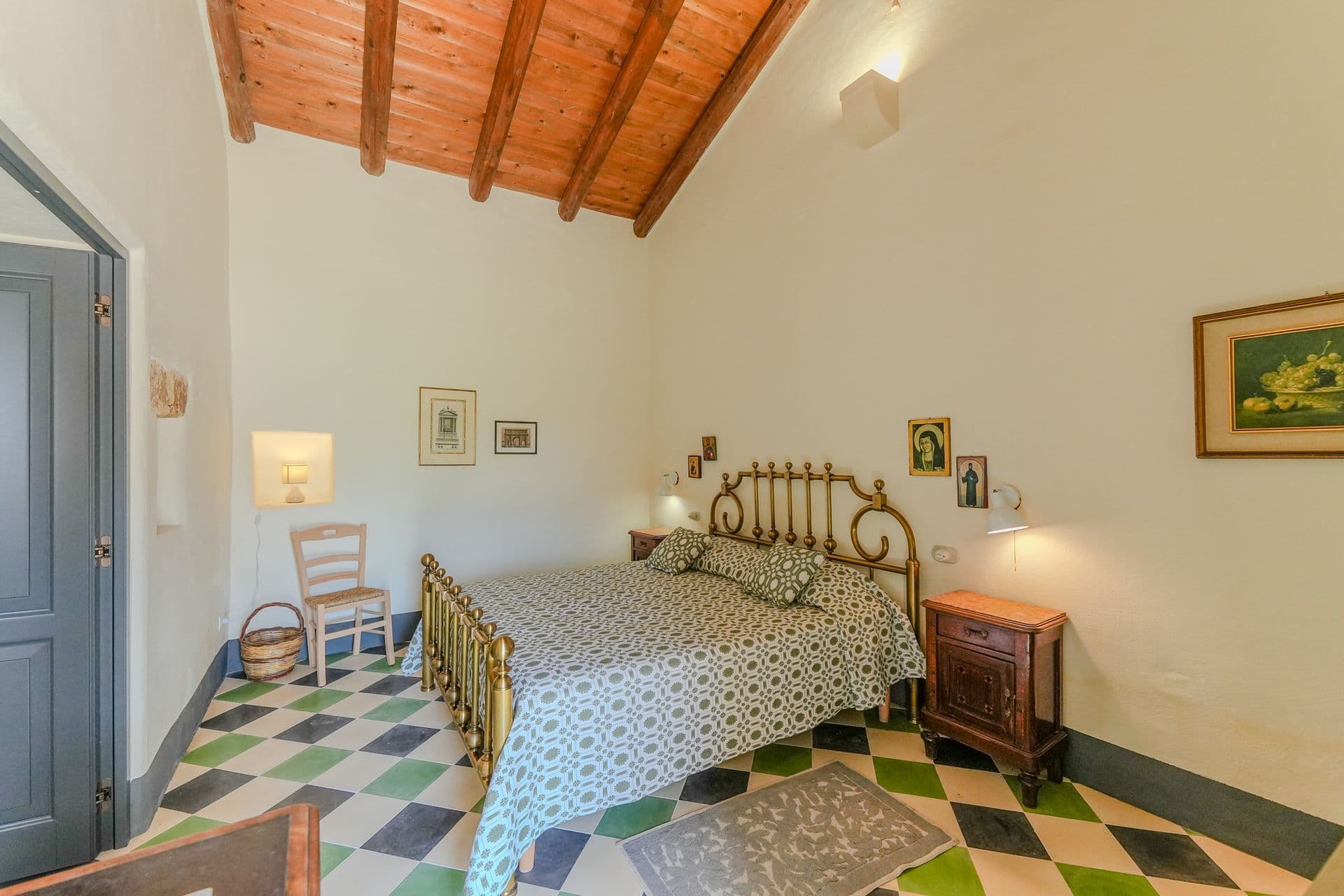 Bedroom with brass bed frame and checkered floor at Puglian Farmhouse