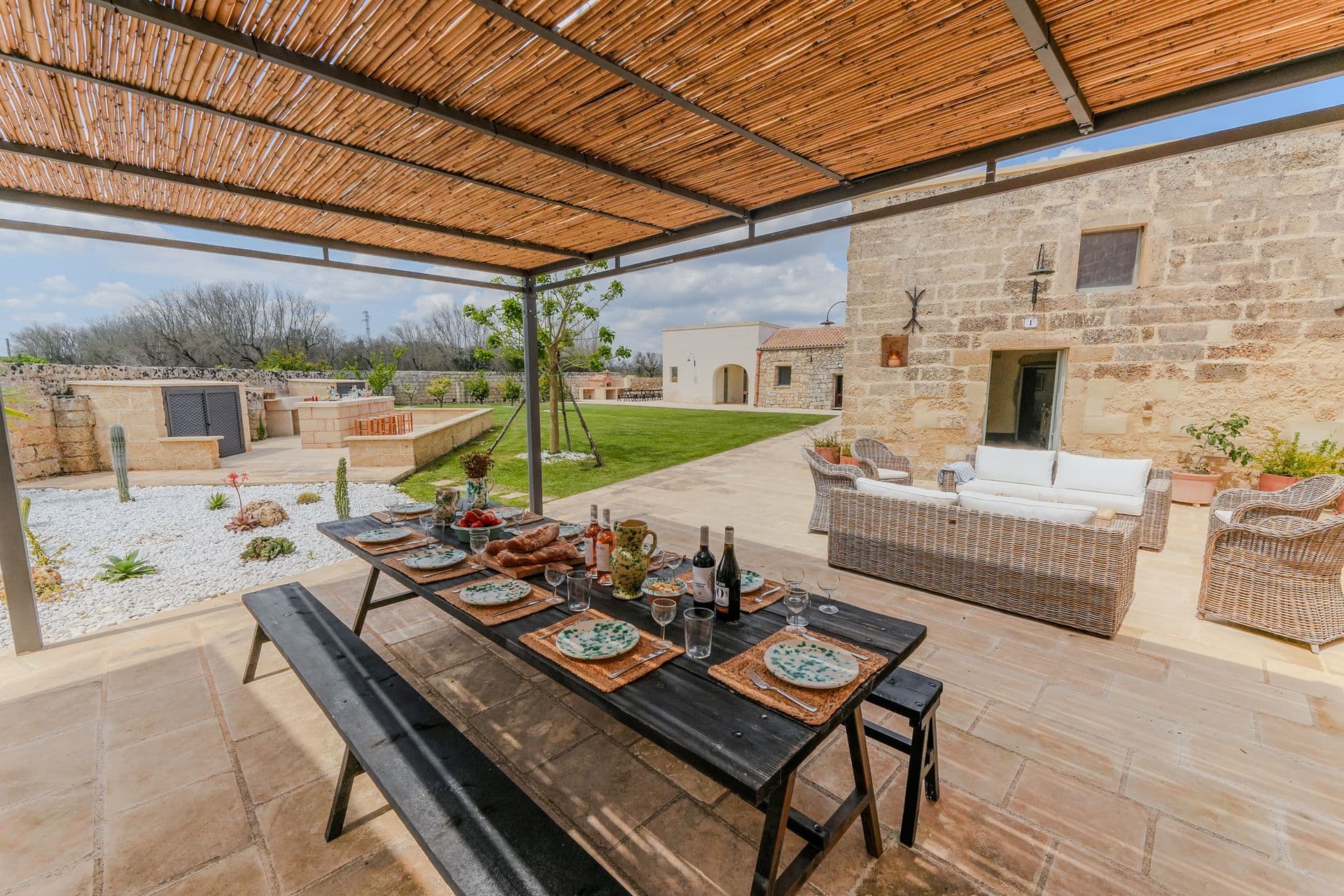 Covered terrace dining table with reed roof at Puglian Farmhouse