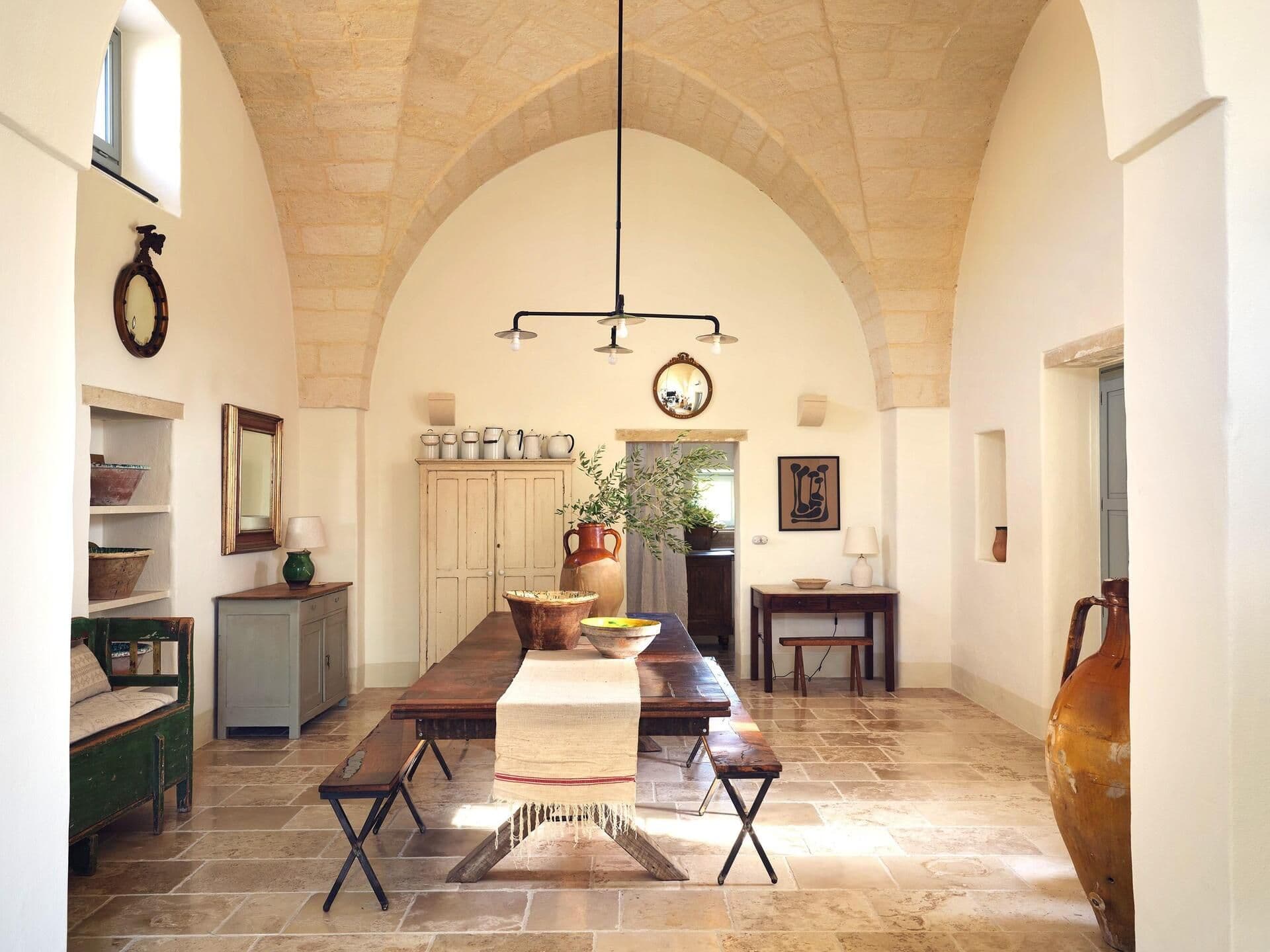 Vaulted dining room with stone archway at Puglian Farmhouse