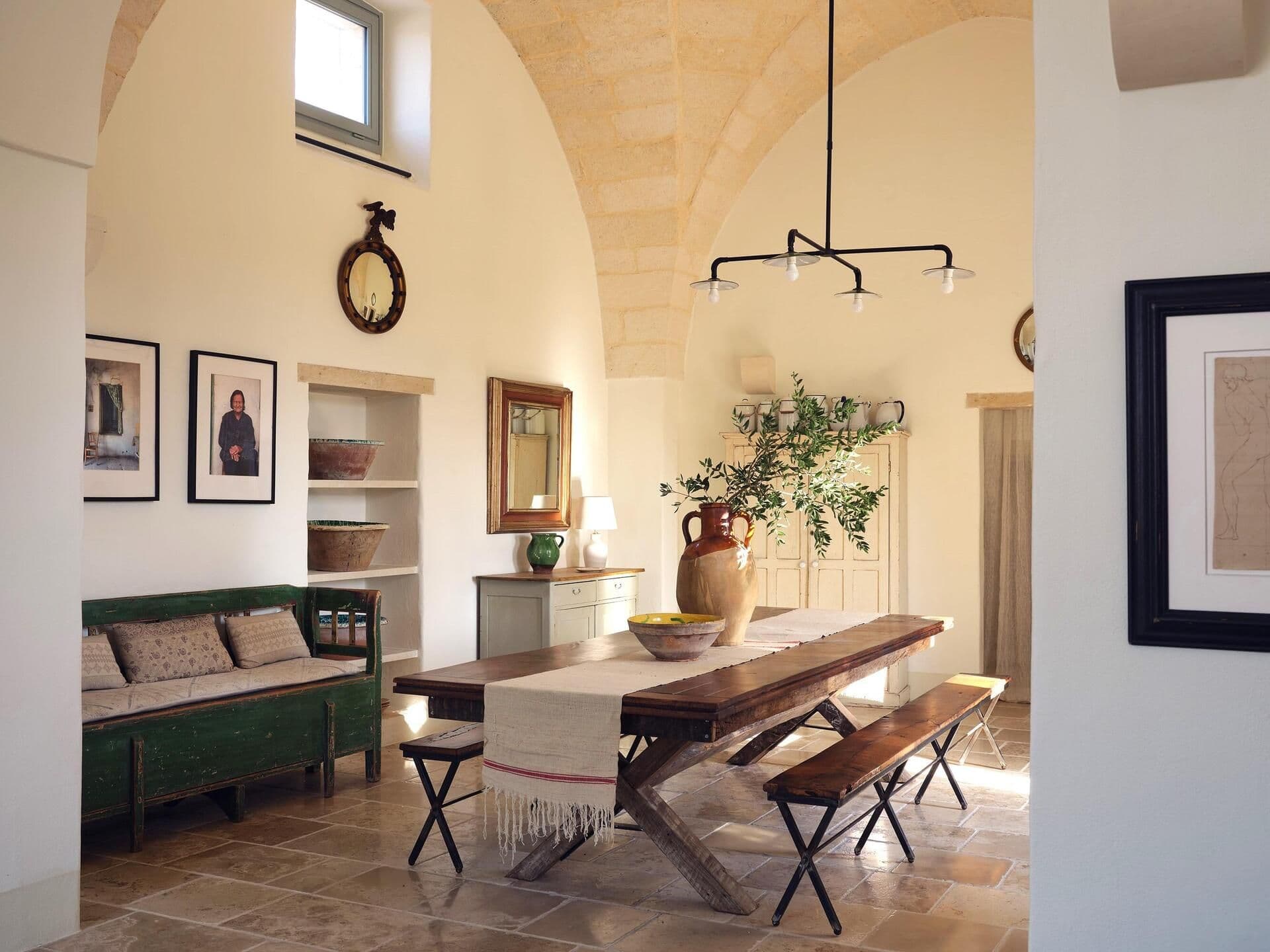 Rustic dining room with vaulted ceiling and long table at Puglian Farmhouse