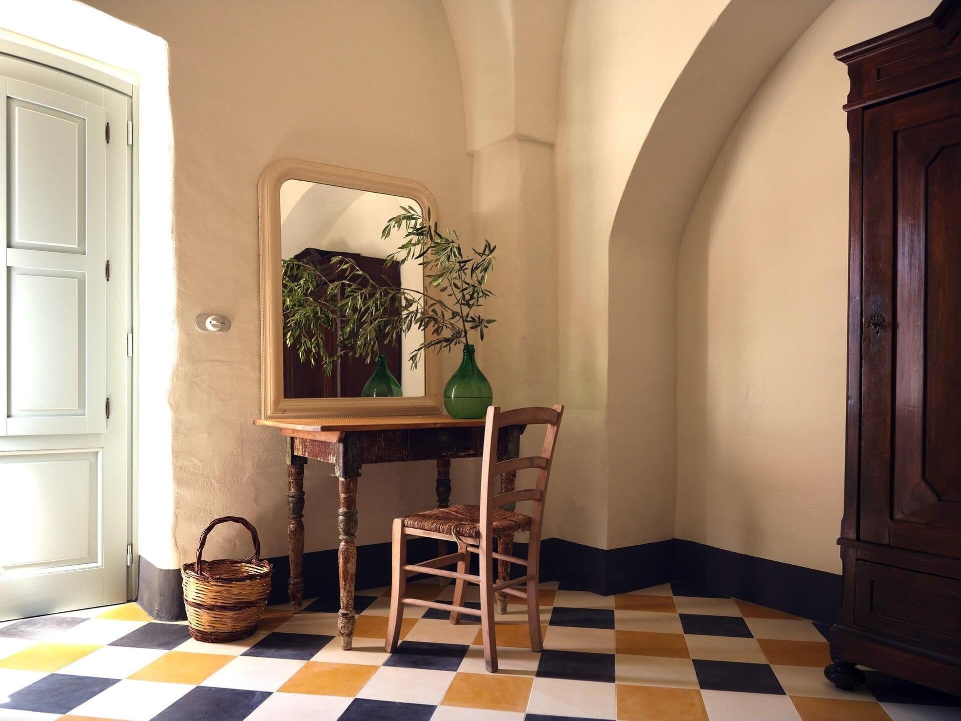 Entrance hall with antique furniture and checkered floor at Puglian Farmhouse
