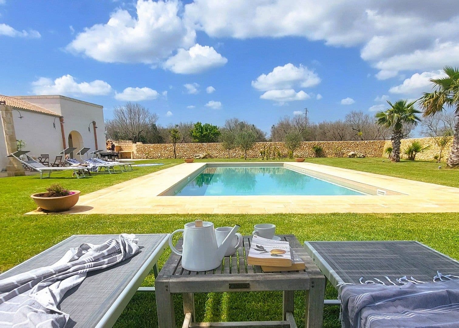 Swimming pool with sun loungers on the lawn at Puglian Farmhouse
