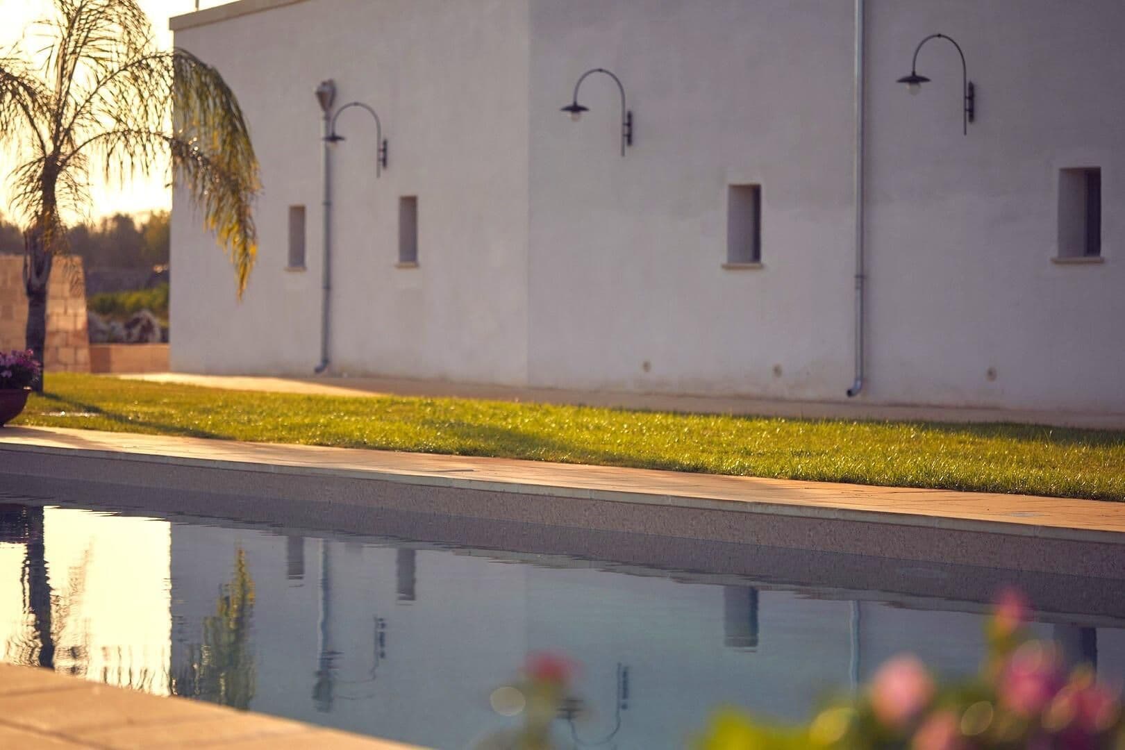Stone farmhouse facade reflected in the pool at twilight at Puglian Farmhouse, Lecce