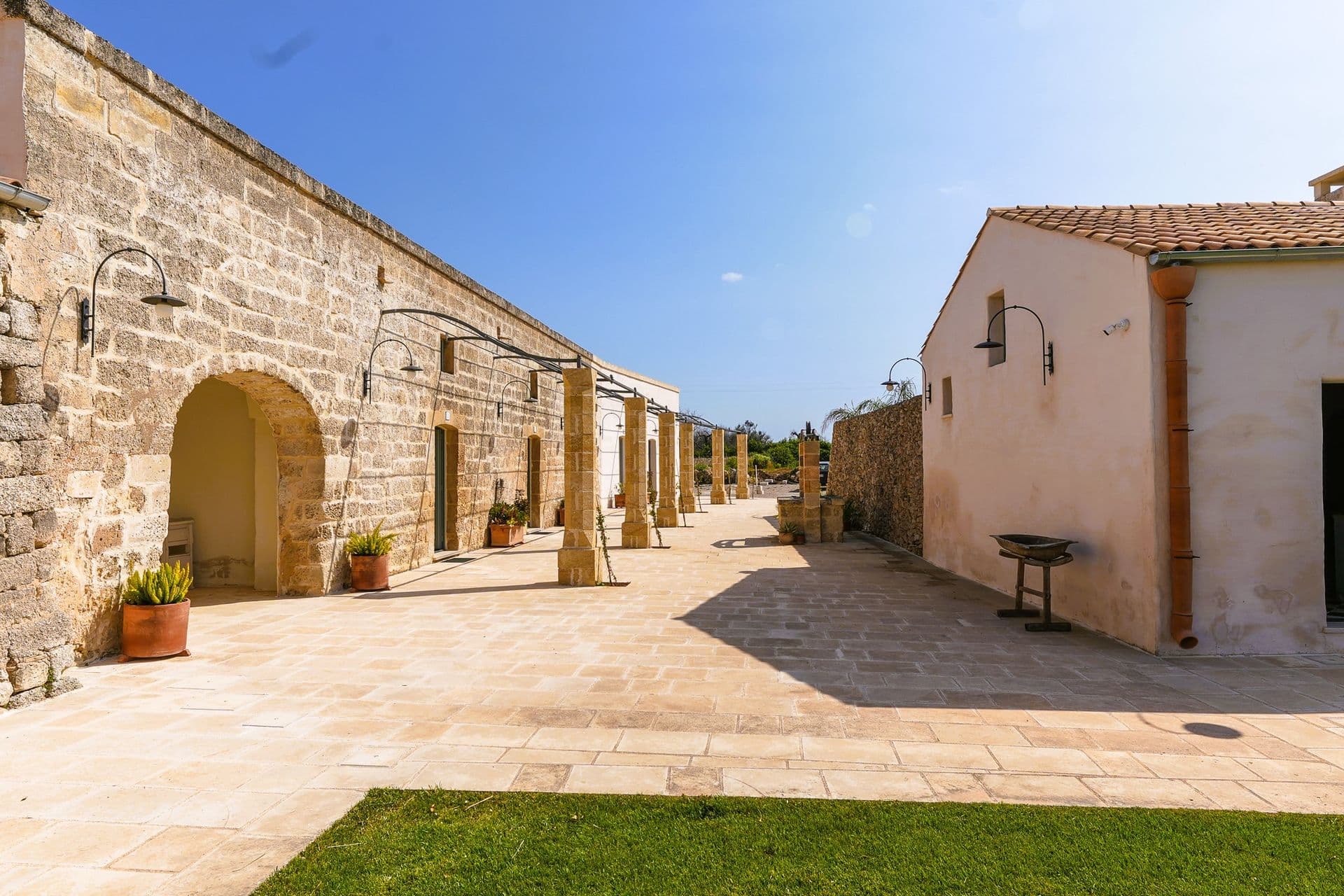 Covered stone walkway through the courtyard at Puglian Farmhouse