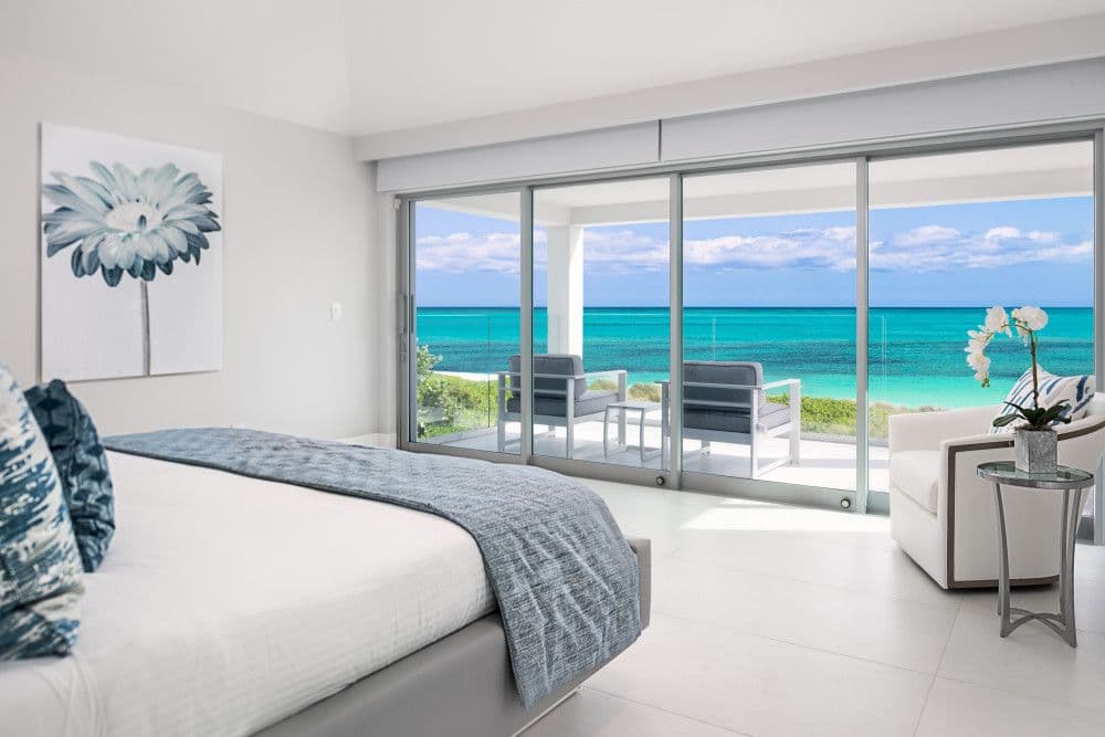 Oceanfront bedroom with sliding doors to a sea-view terrace