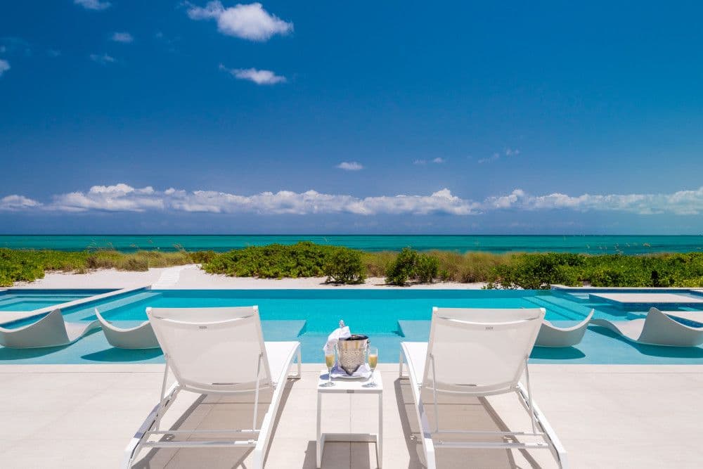 Poolside loungers facing the turquoise ocean at Seaclusion, Grace Bay