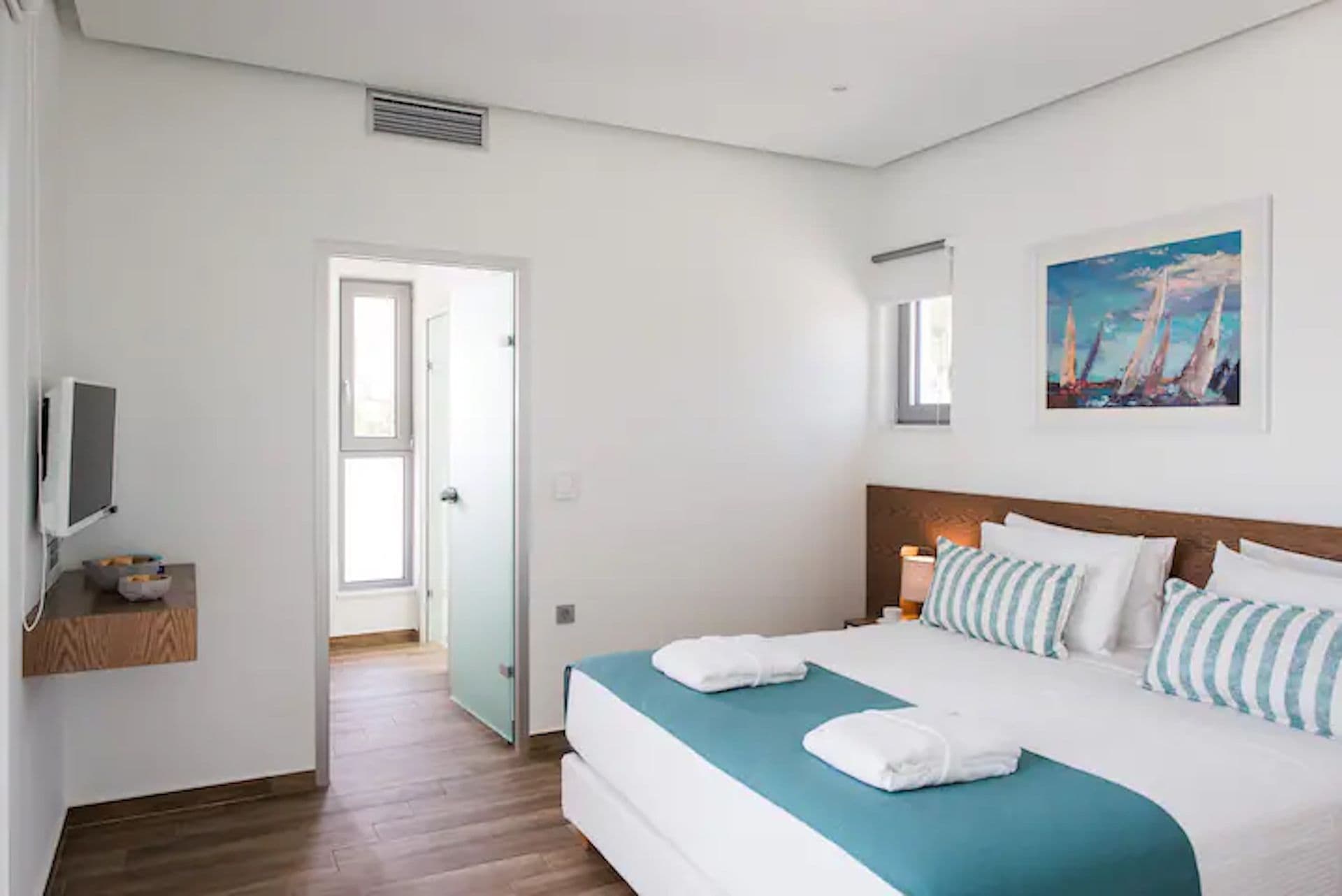 White kitchen with a breakfast bar and timber pendant lights at Back to the Sea, Greece