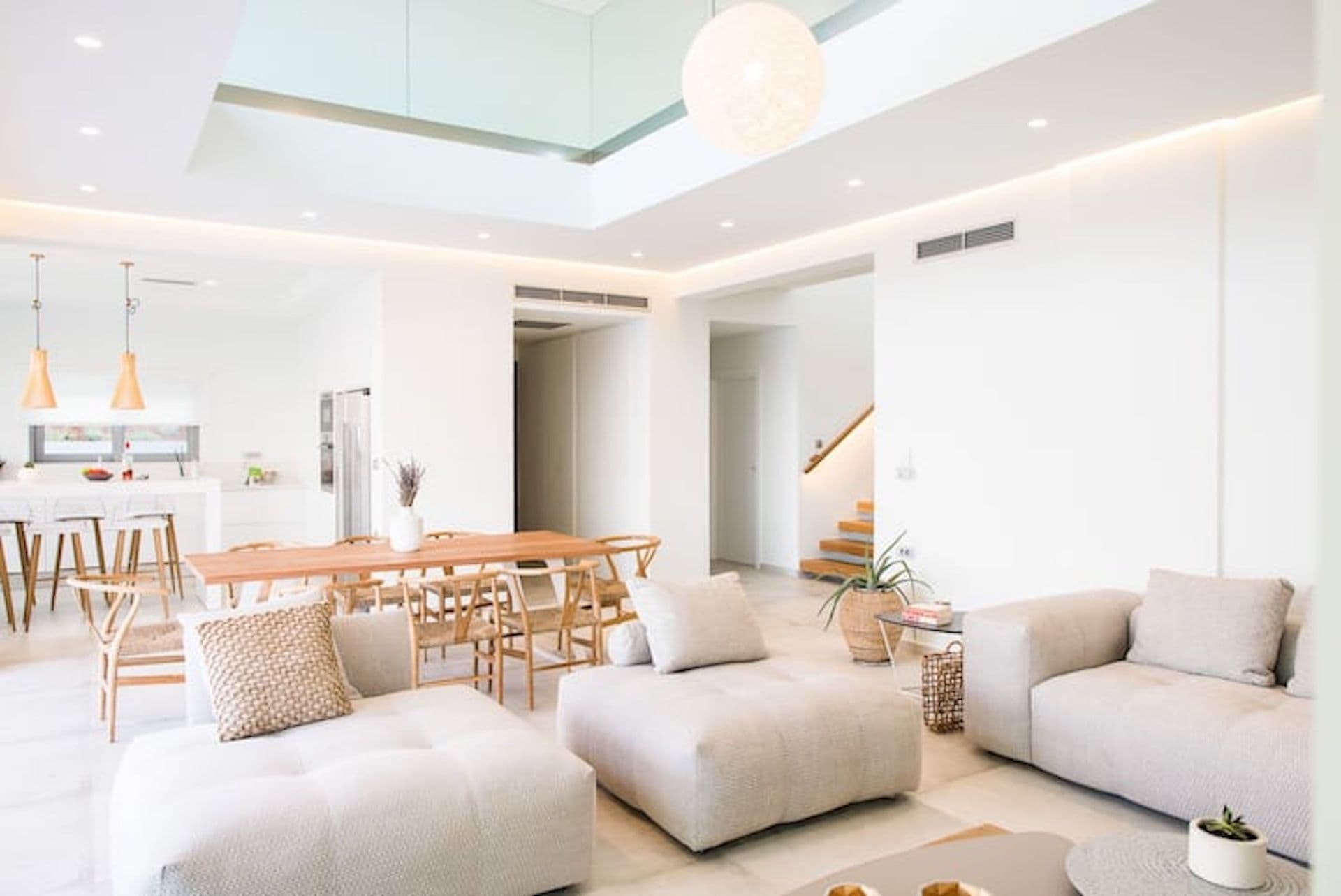 Open-plan living and dining area in white and oak at Back to the Sea, Greece