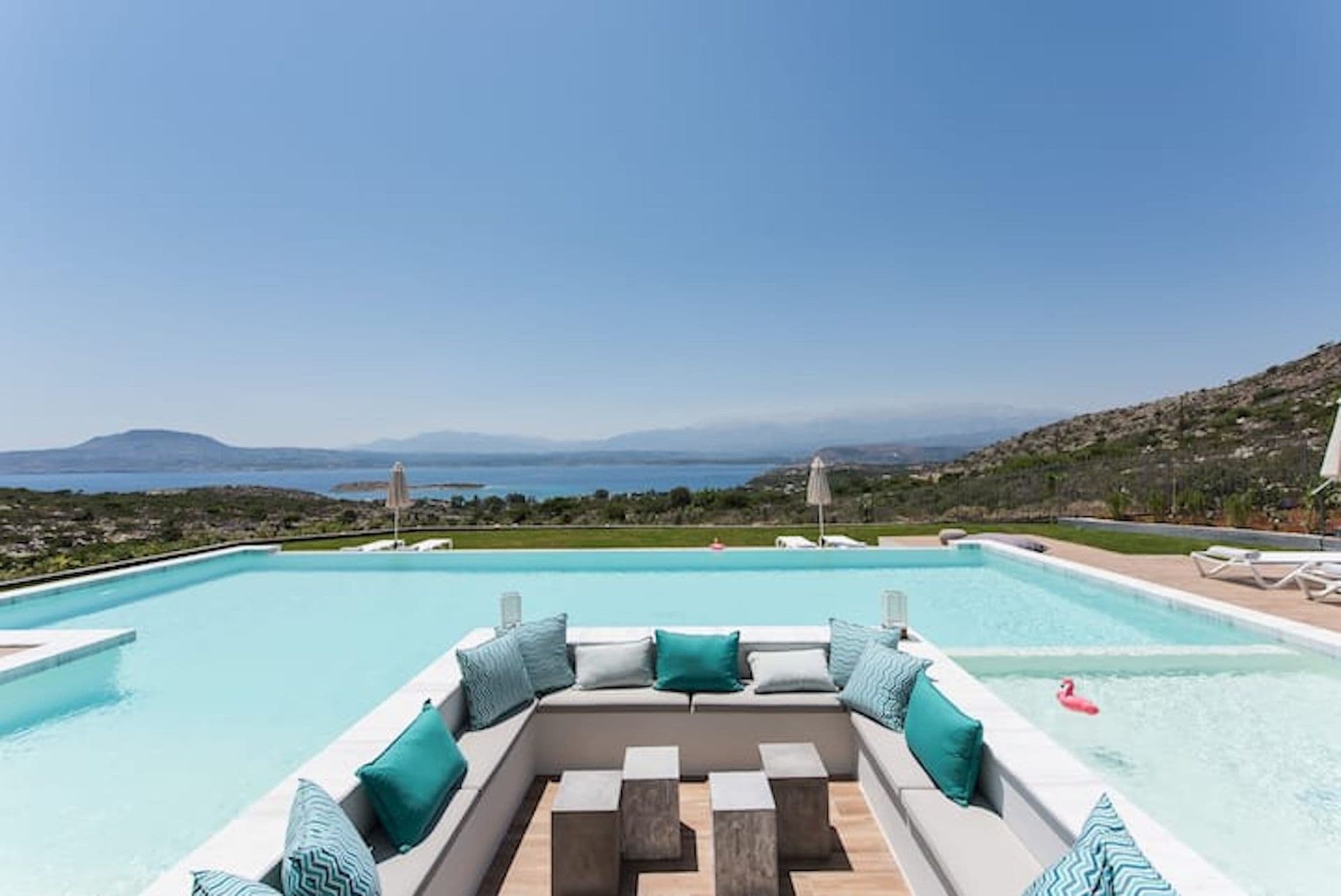 Sunken poolside lounge with turquoise cushions above the bay at Back to the Sea, Greece