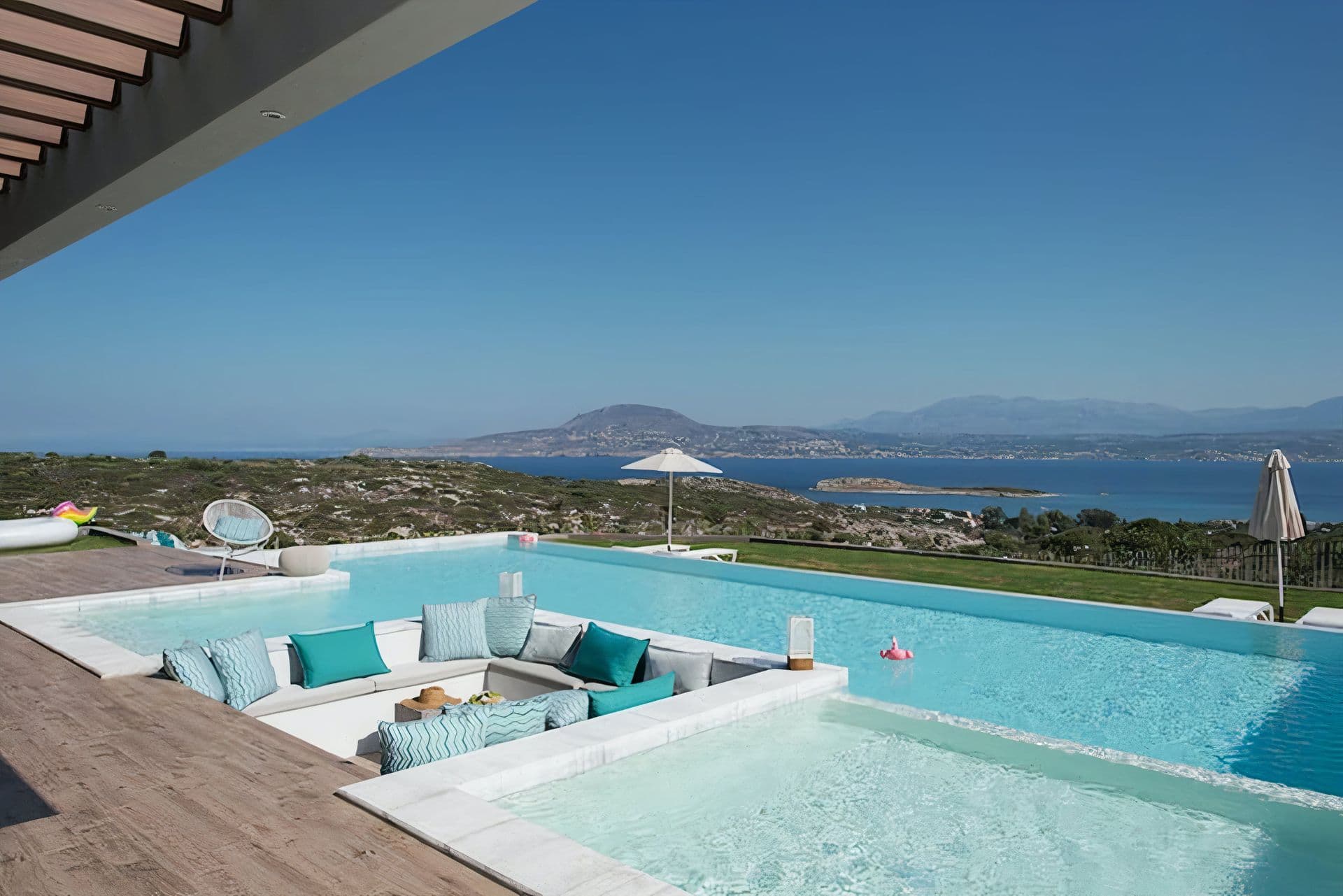 Infinity pool with a sunken seating pit overlooking a bay and islands at Back to the Sea, Greece