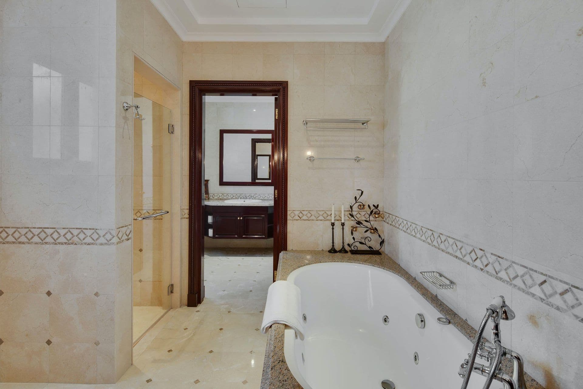 En-suite bathroom with a corner jacuzzi tub and marble tiling.