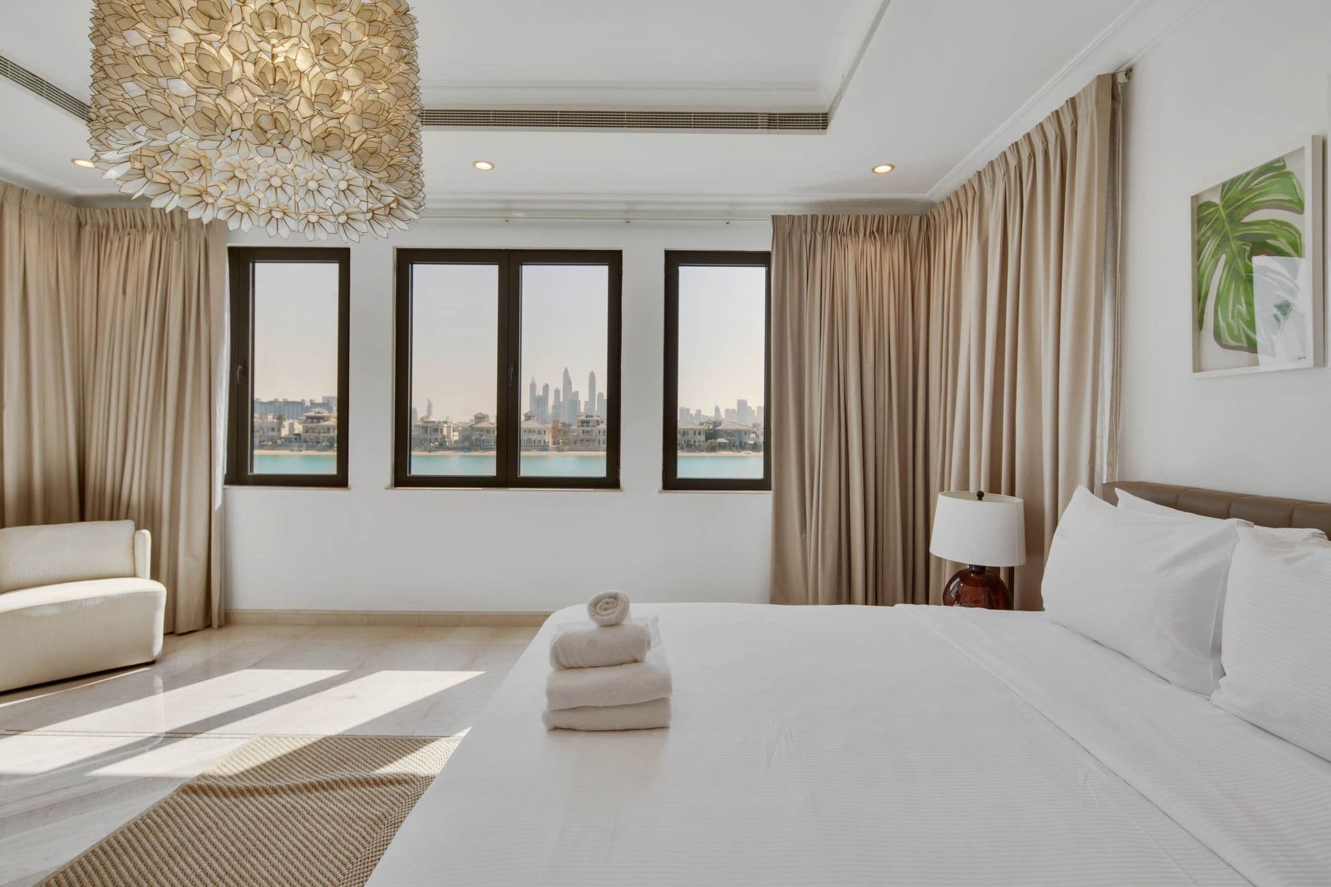 Guest bedroom with twin windows framing the Dubai skyline.