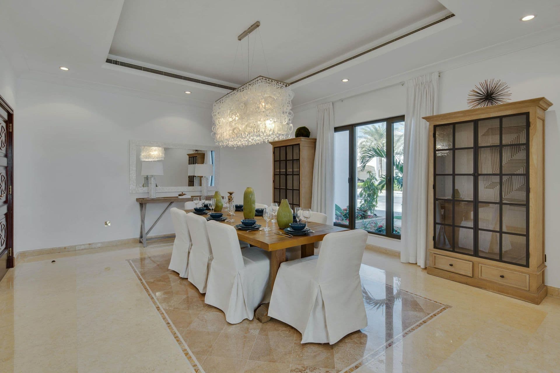 Formal dining room seating eight, with a display cabinet and chandelier.