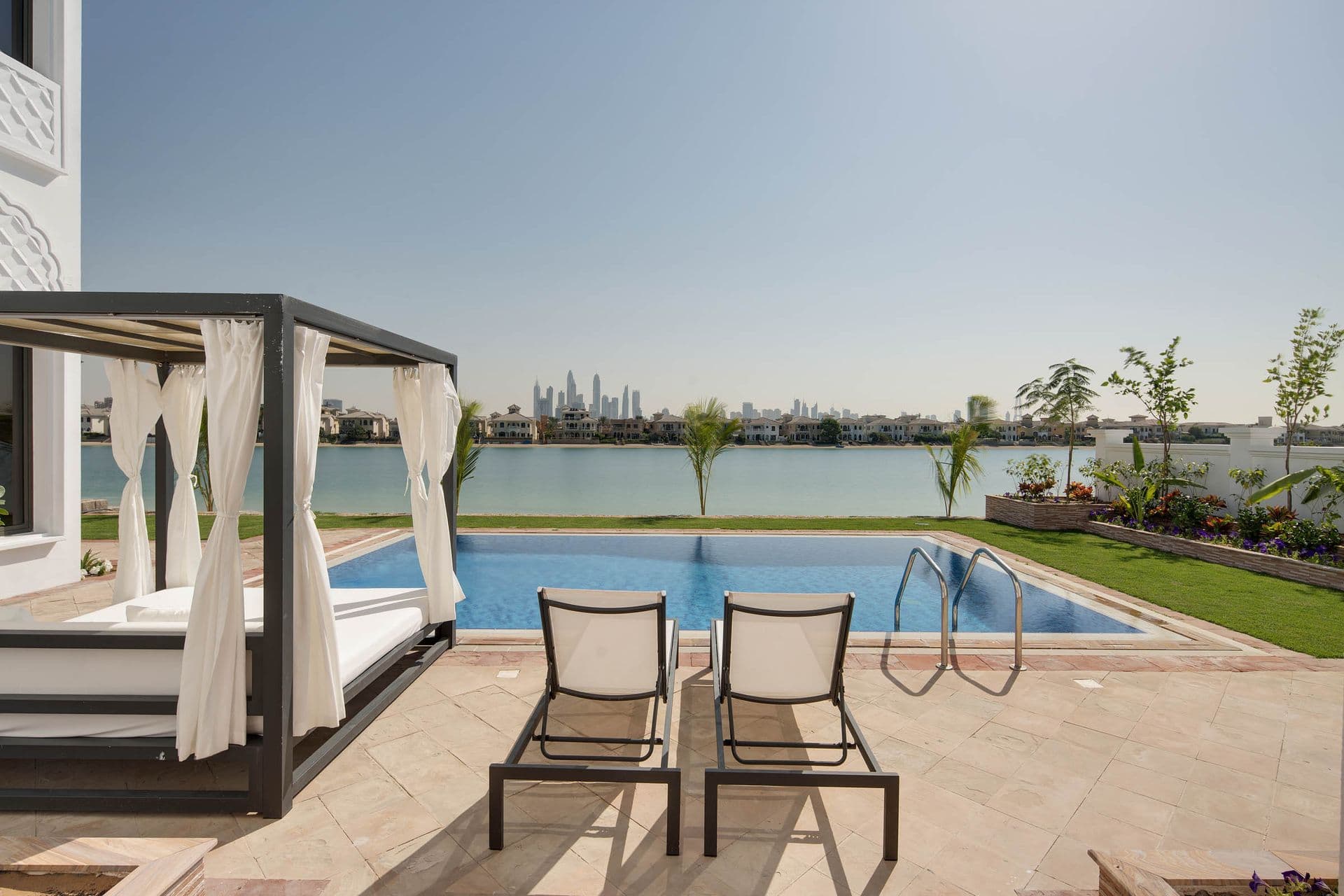 Shaded poolside cabana seating with the marina skyline in the background.