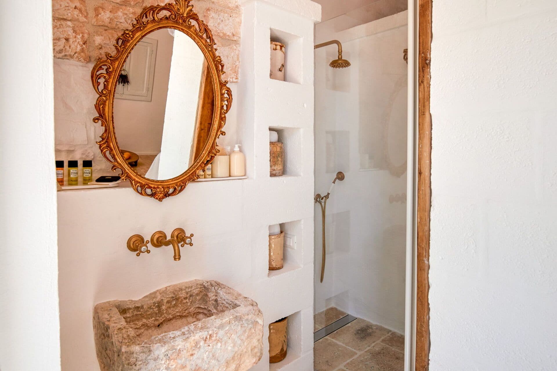 Rustic bathroom with a stone washbasin alcove and rainfall shower at Mediterranean Sunhouse