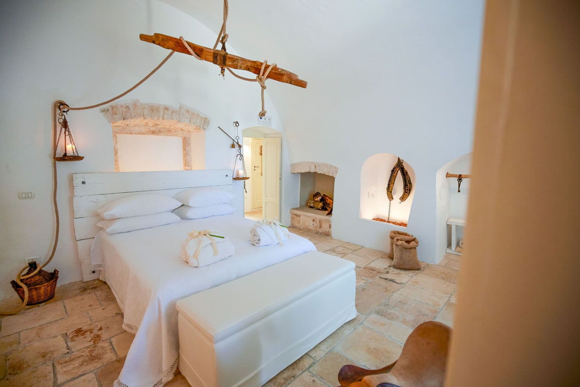 Whitewashed bedroom with a vaulted stone archway and hanging lanterns above the bed at Mediterranean Sunhouse