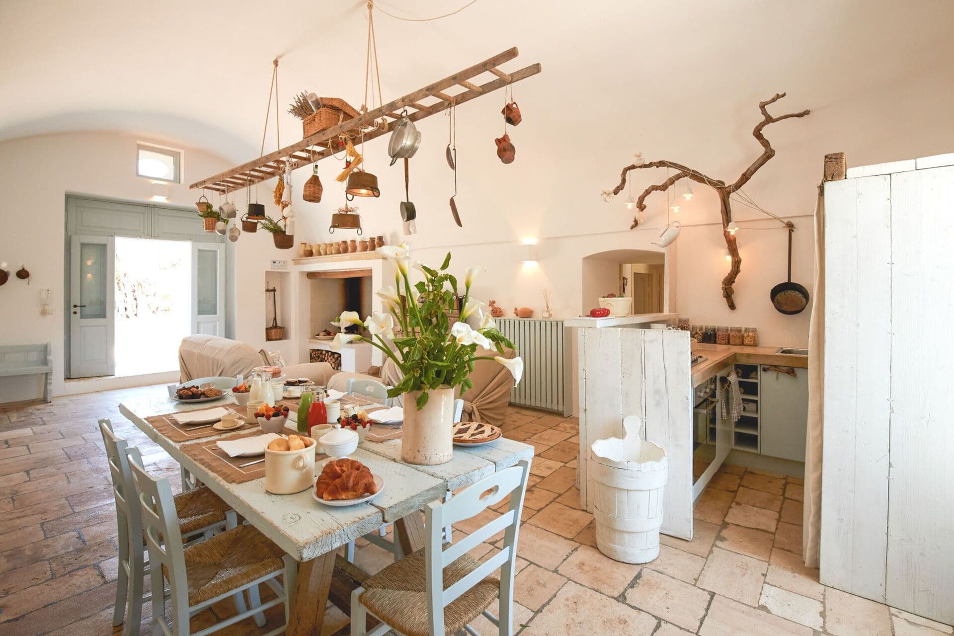 Open plan dining and kitchen area with terracotta floor tiles and traditional Puglian decor at Mediterranean Sunhouse