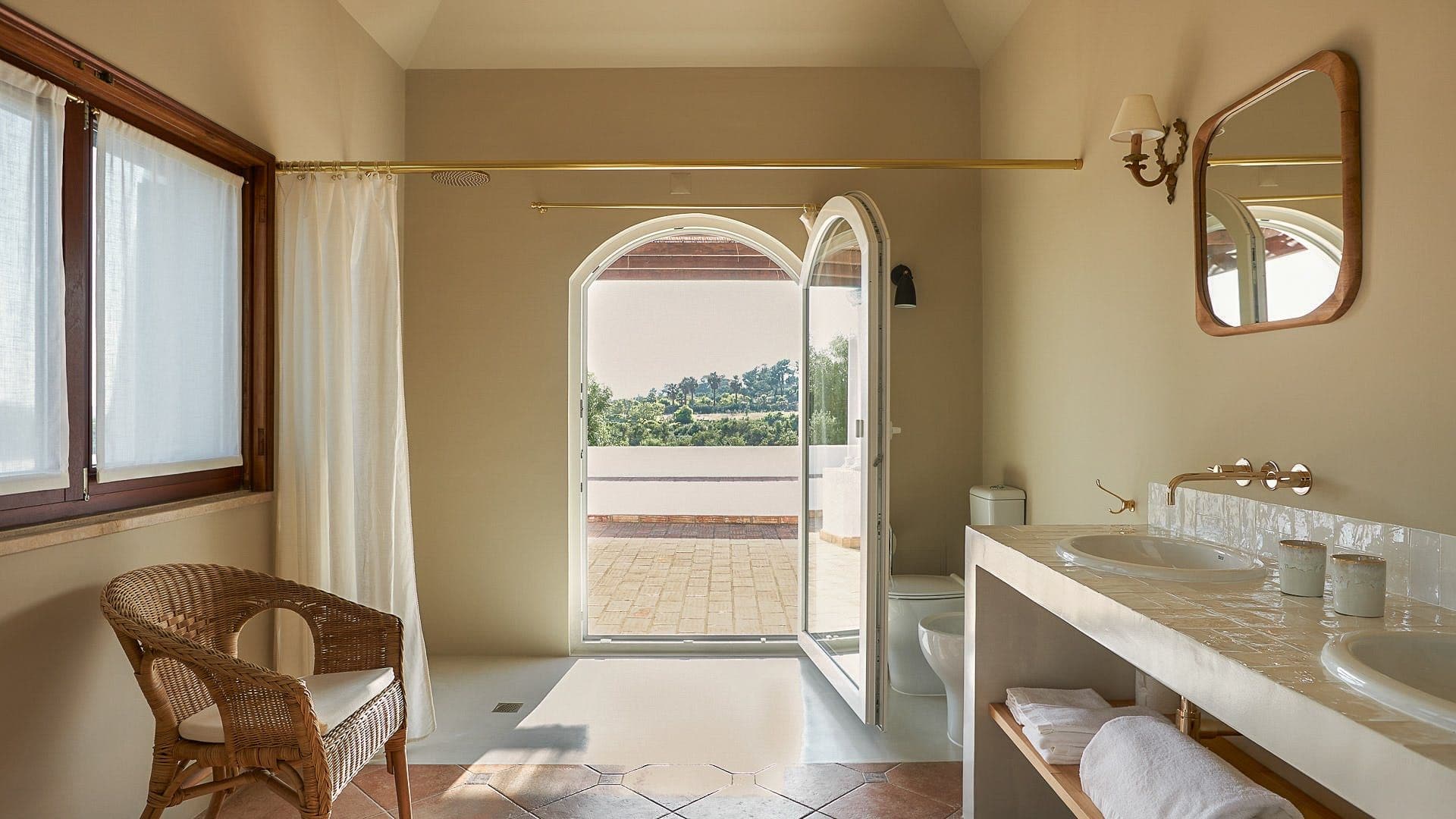 Ensuite bathroom with an arched doorway opening directly onto a private terrace