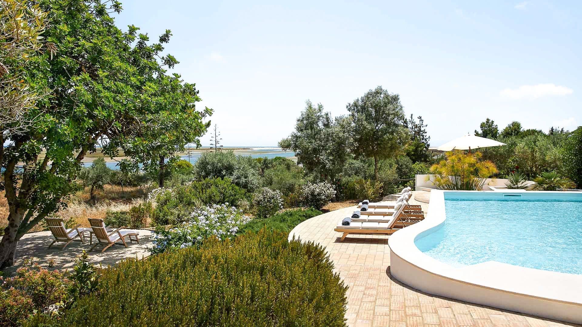 Wild Peace farmhouse estate near Tavira with a curved pool set among lush Algarve gardens