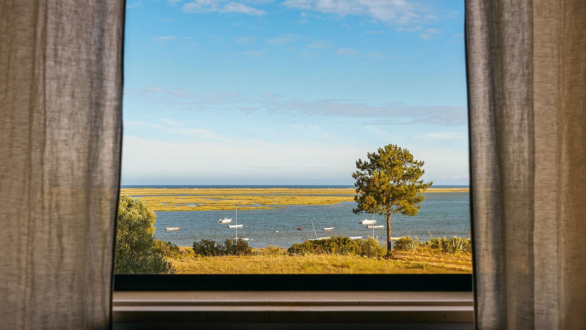 View of the Ria Formosa lagoon framed through a bedroom window