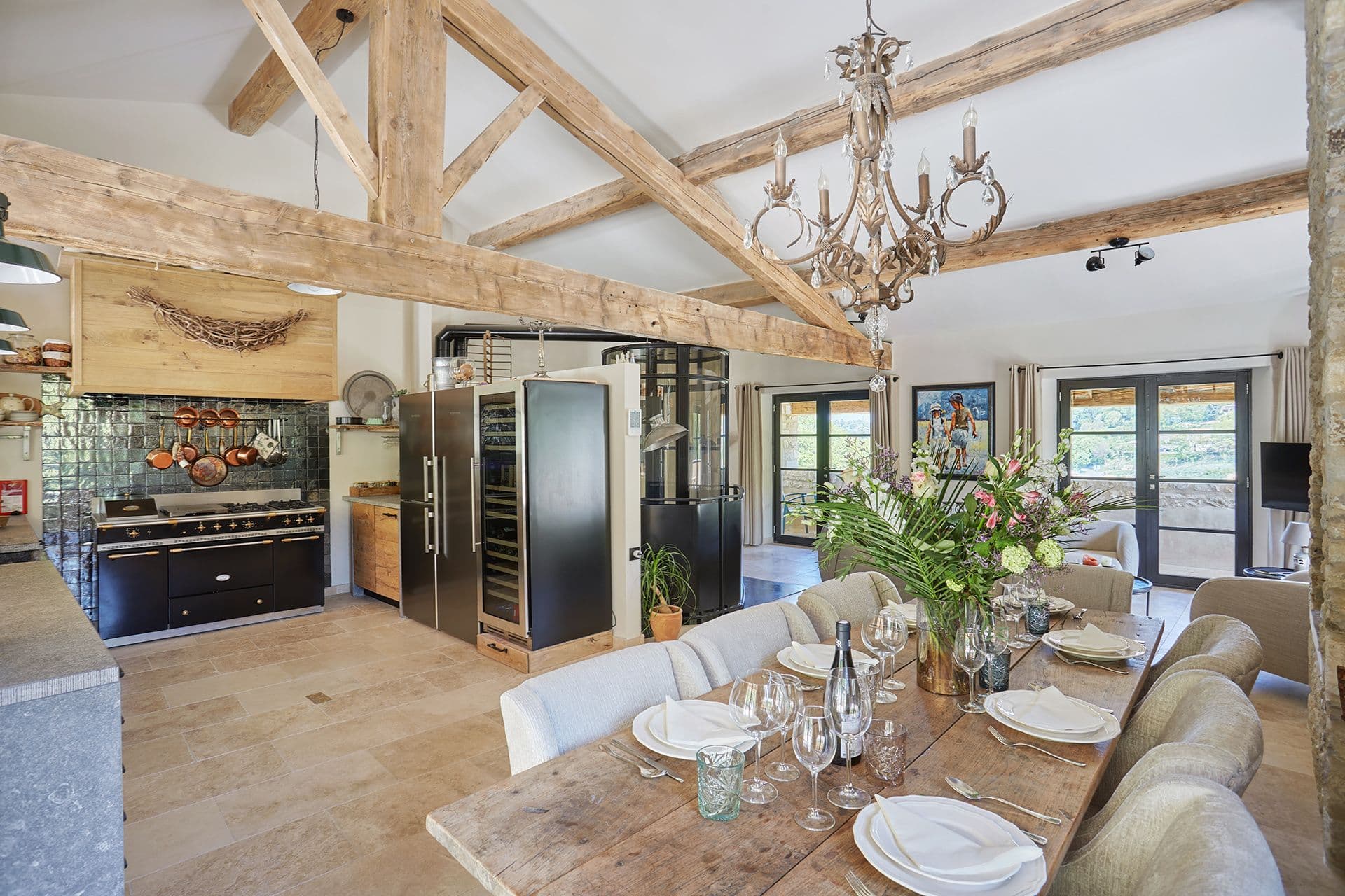 Range cooker, wine fridge and a laid oak dining table in the open-plan kitchen at A Glass of Champagne, Provence
