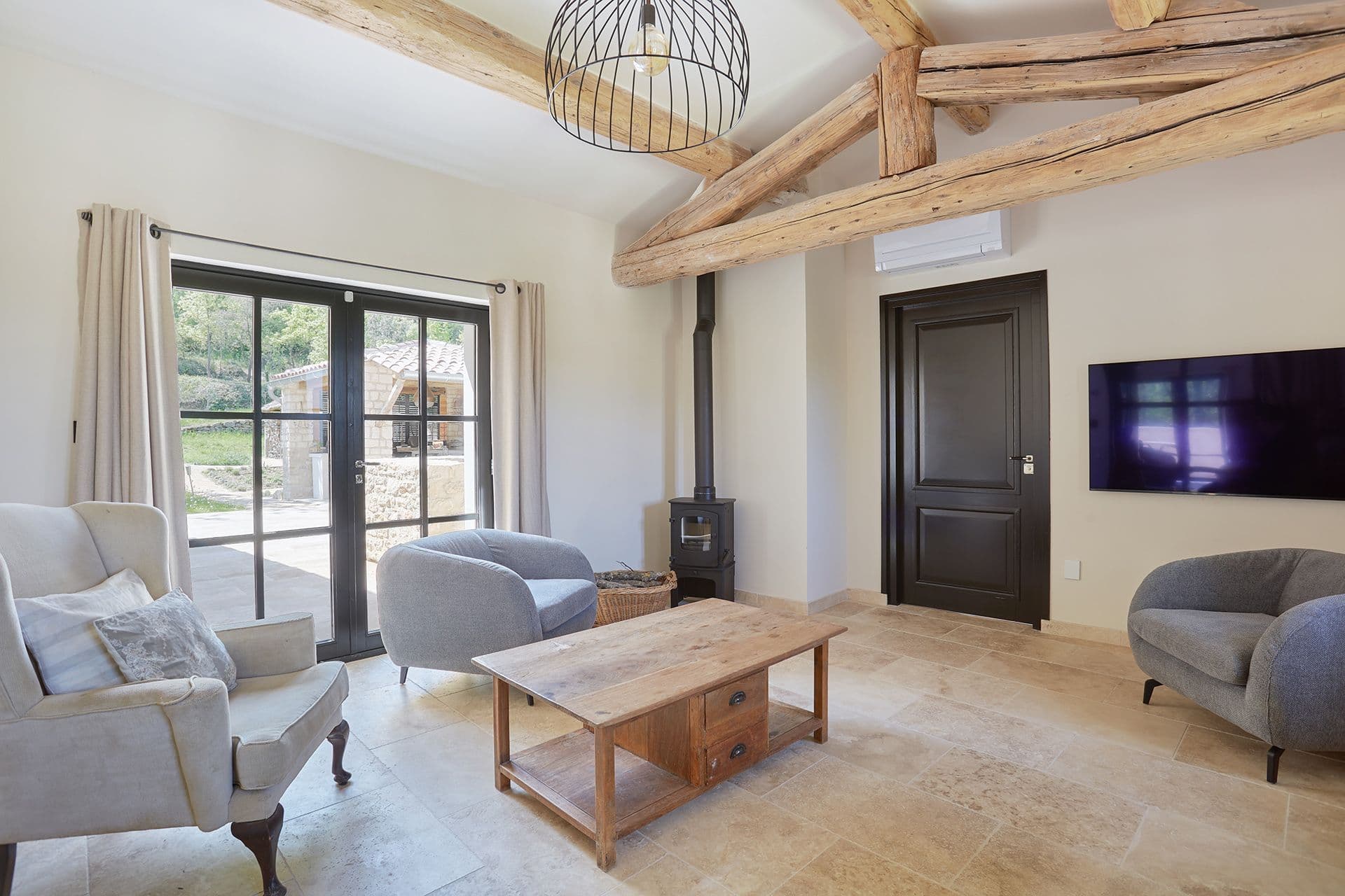 Cosy media snug with a wood-burning stove, television and terrace doors at A Glass of Champagne, Provence