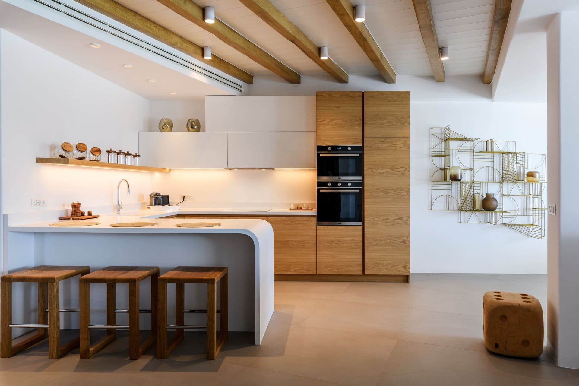 Kitchen in white and oak with an island breakfast bar at Cycladic Sunset Stay, Mykonos