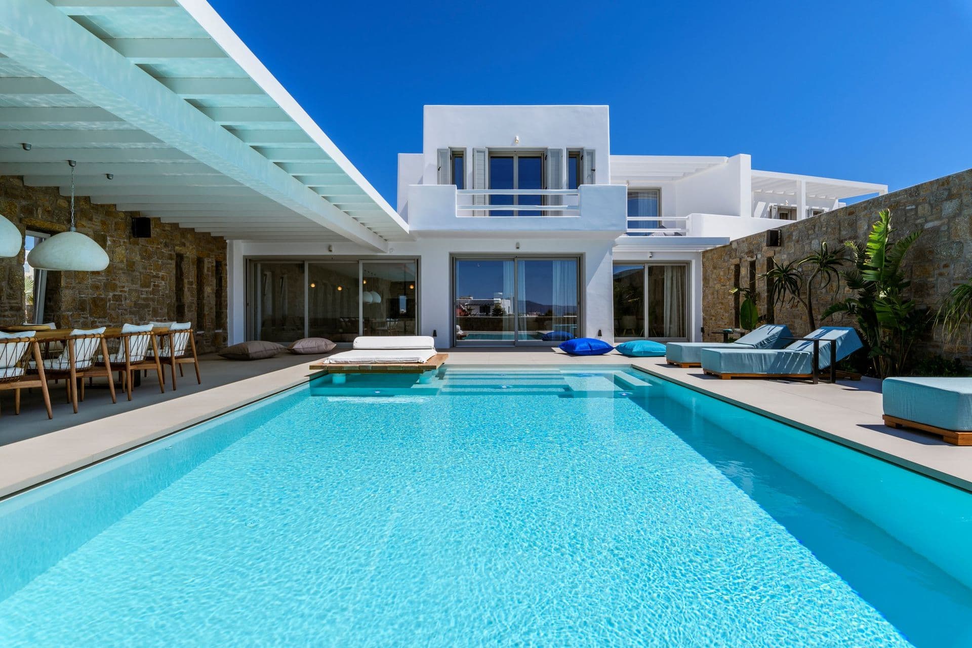 Large swimming pool and loungers beside the white Cycladic villa at Cycladic Sunset Stay, Mykonos
