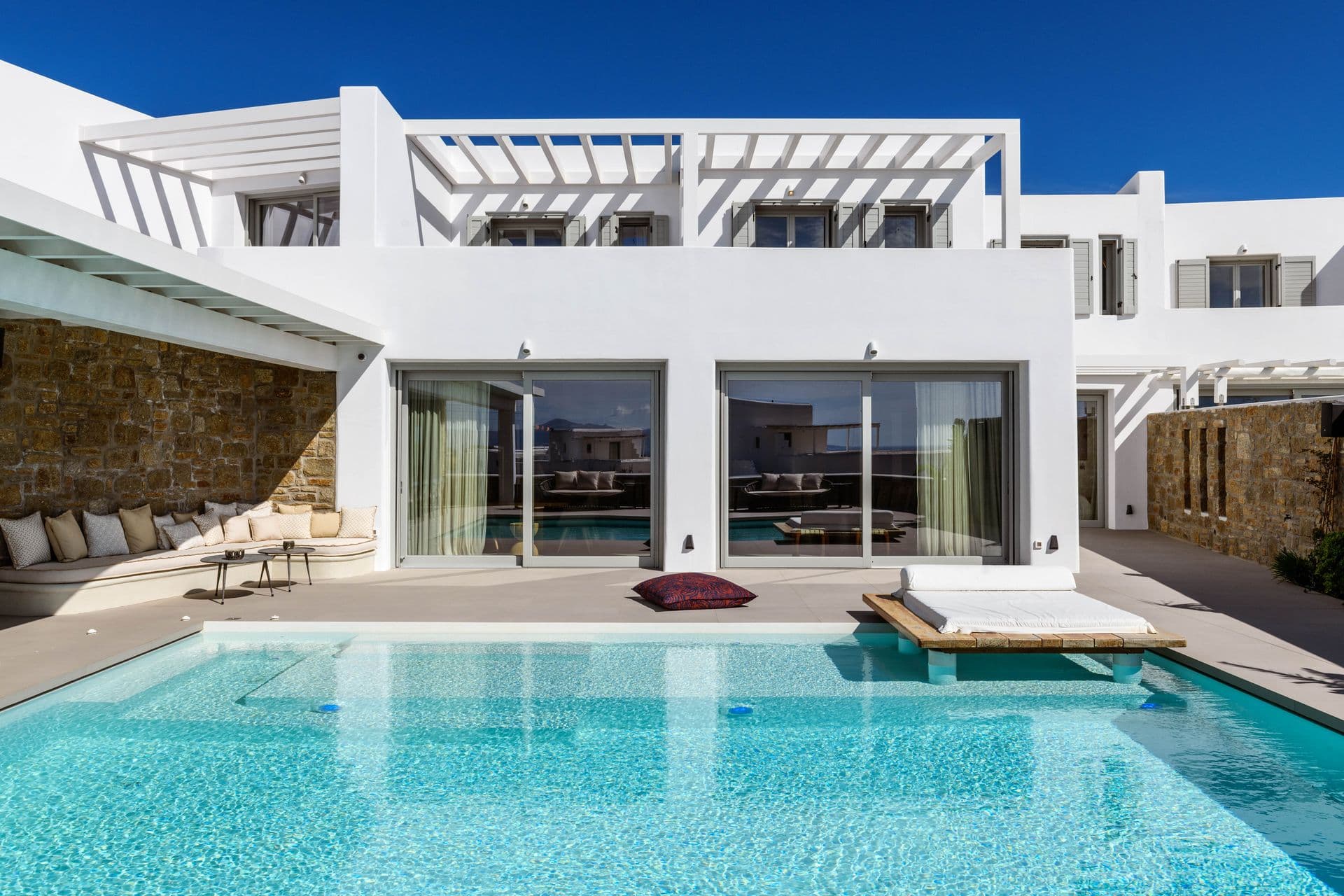 White villa with a pergola terrace beside the pool at Cycladic Sunset Stay, Mykonos