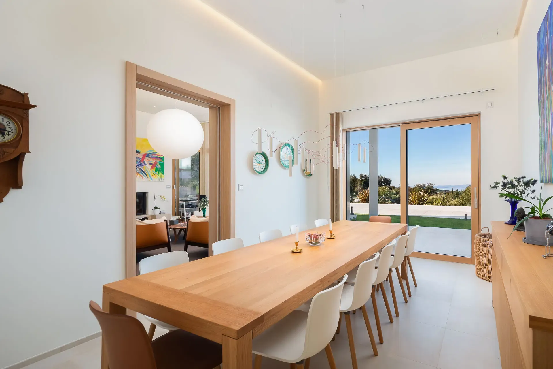 Long dining table at Highland Avenue set beneath full height windows with garden views.