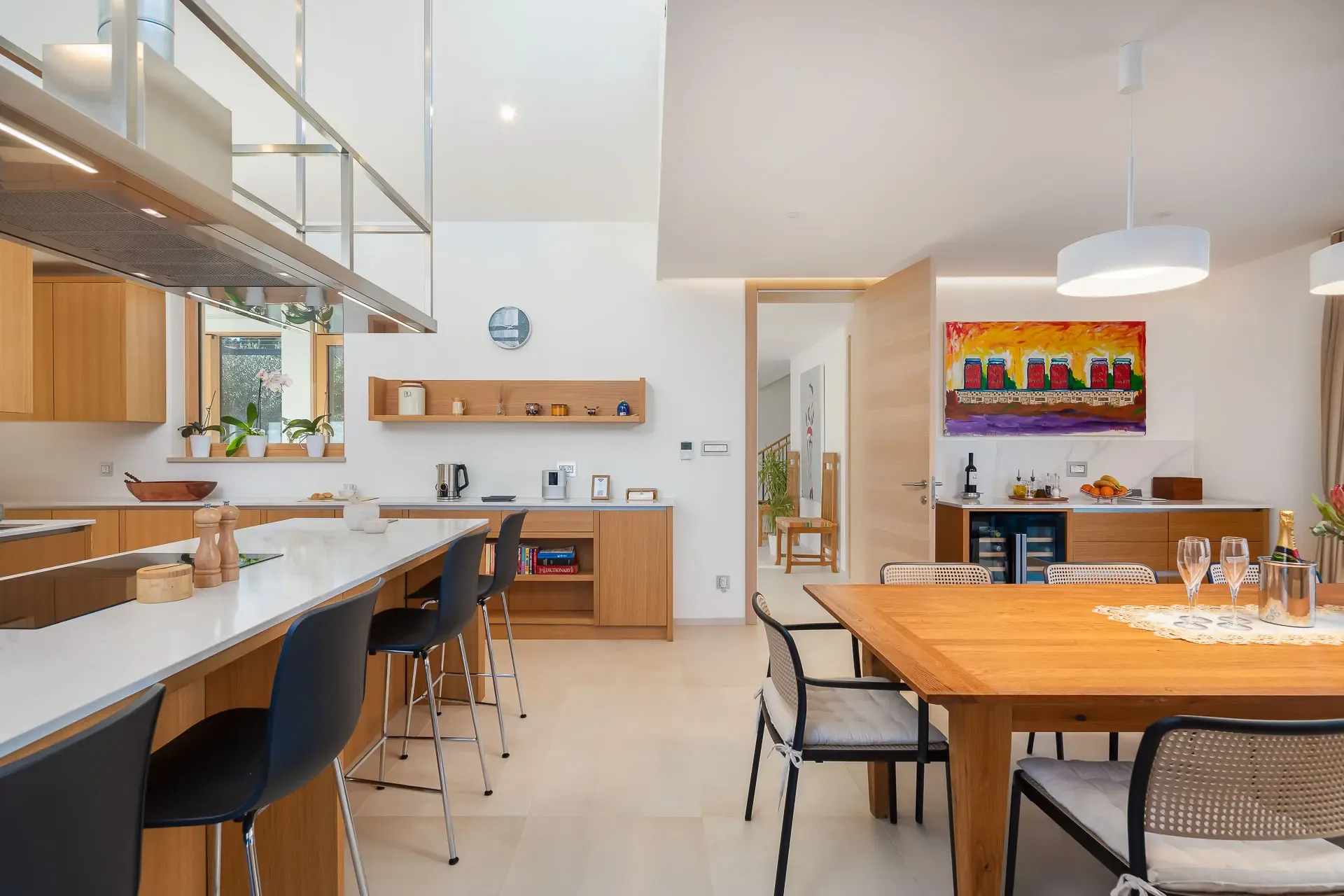 Kitchen and adjoining dining table at Highland Avenue with sheer curtains and natural light.