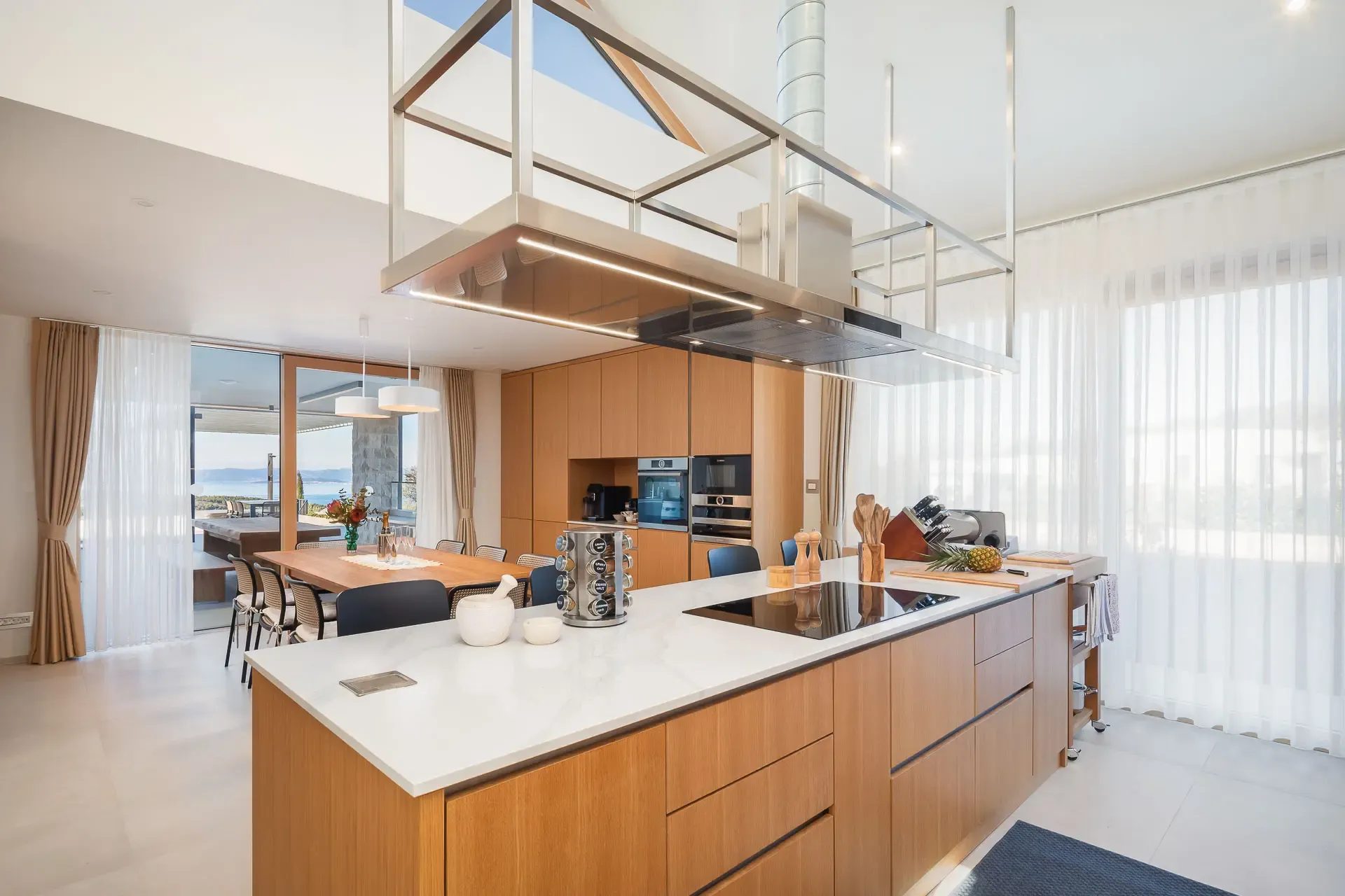 Kitchen island beneath a suspended extractor hood at Highland Avenue.
