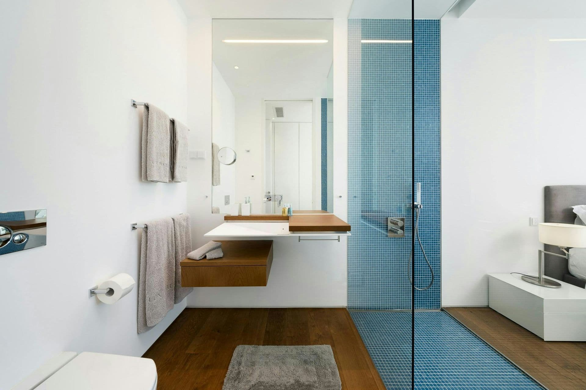 En-suite bathroom in blue mosaic with a double vanity at A Coastal Crown, Lagos