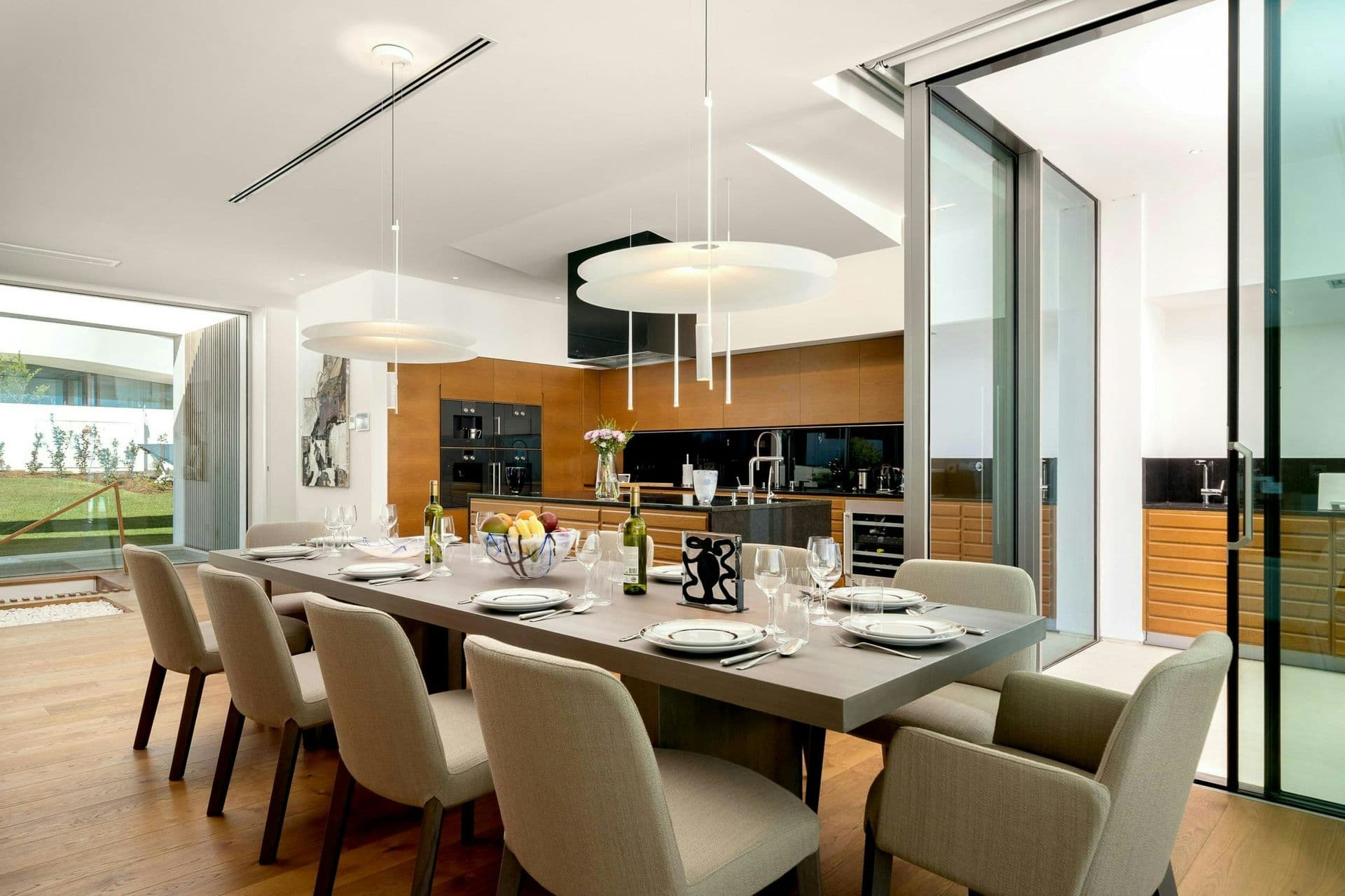 Dining room with a long table and pendant lights at A Coastal Crown, Lagos