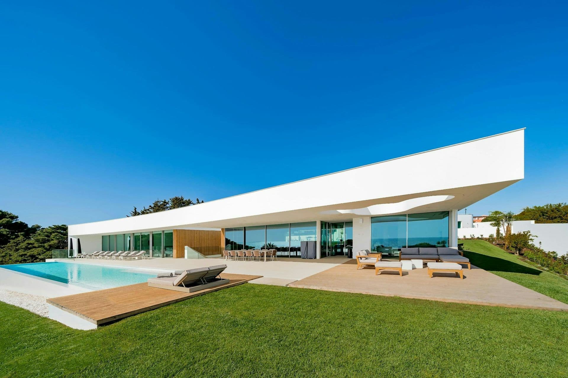 Sculptural white villa with a cantilevered roof and infinity pool above the Atlantic at A Coastal Crown, Lagos