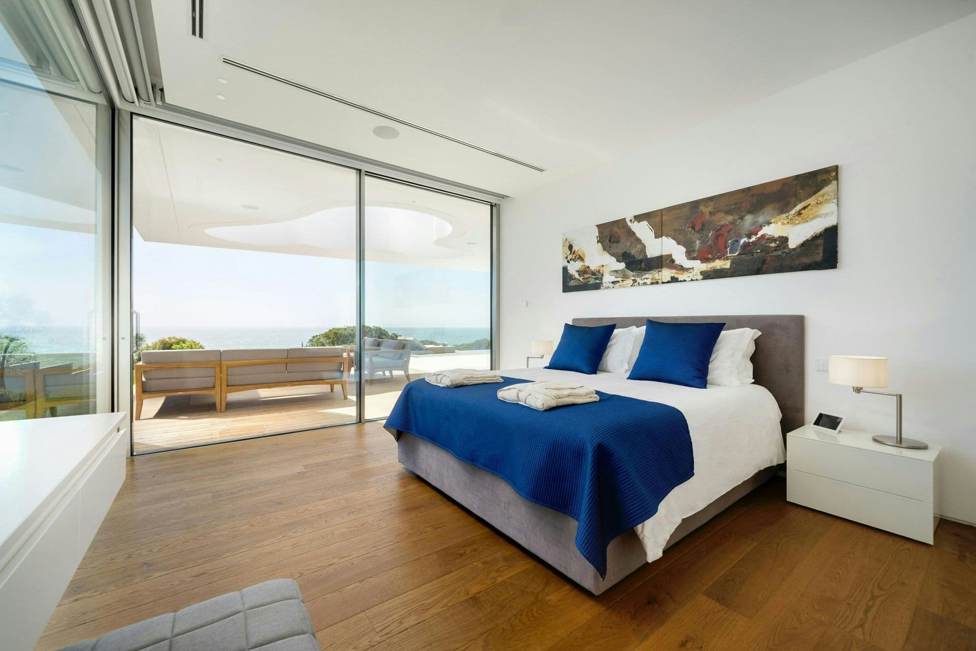 Guest bedroom in blue tones with terrace access at A Coastal Crown, Lagos