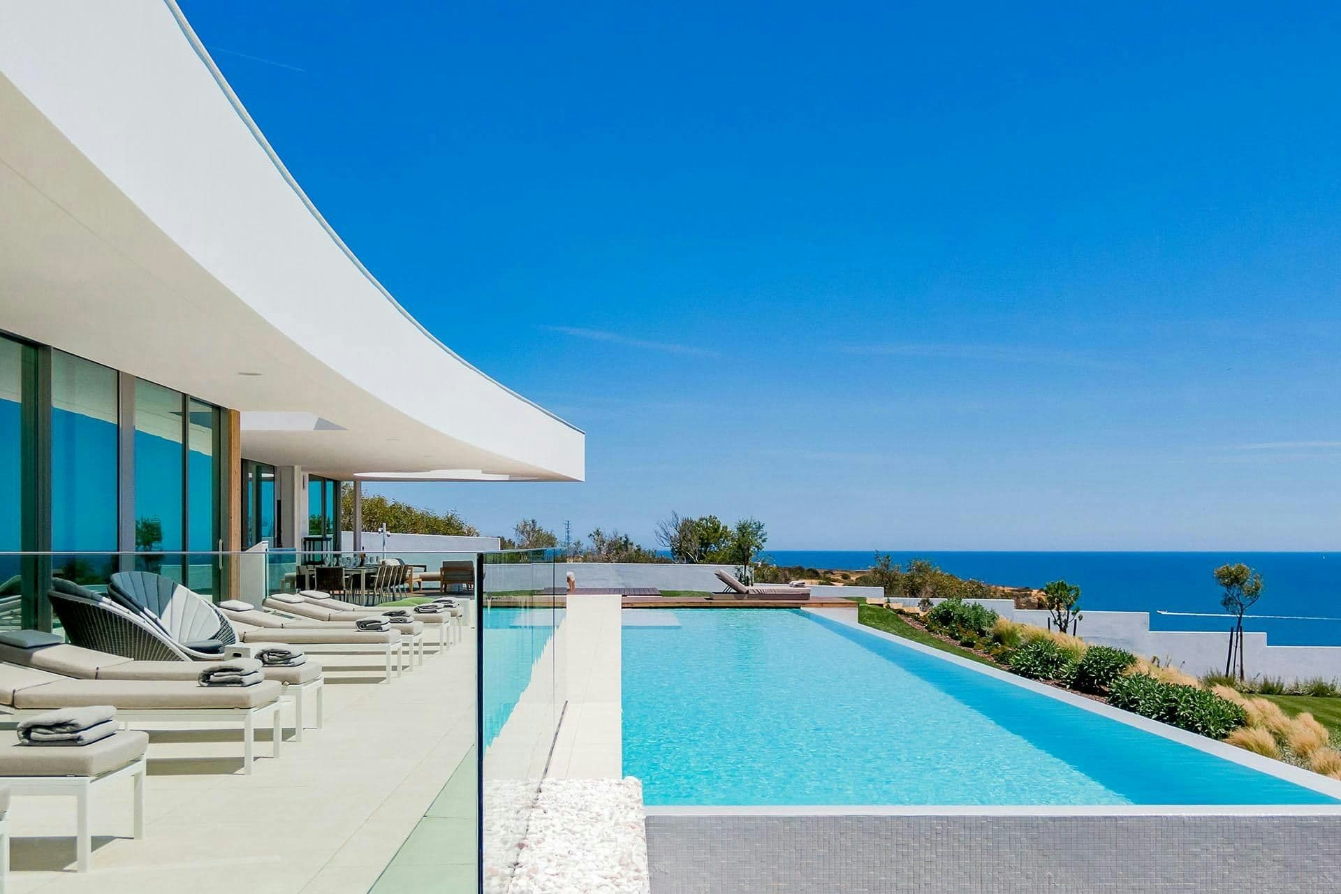 Heated infinity pool with loungers overlooking the Atlantic at A Coastal Crown, Lagos