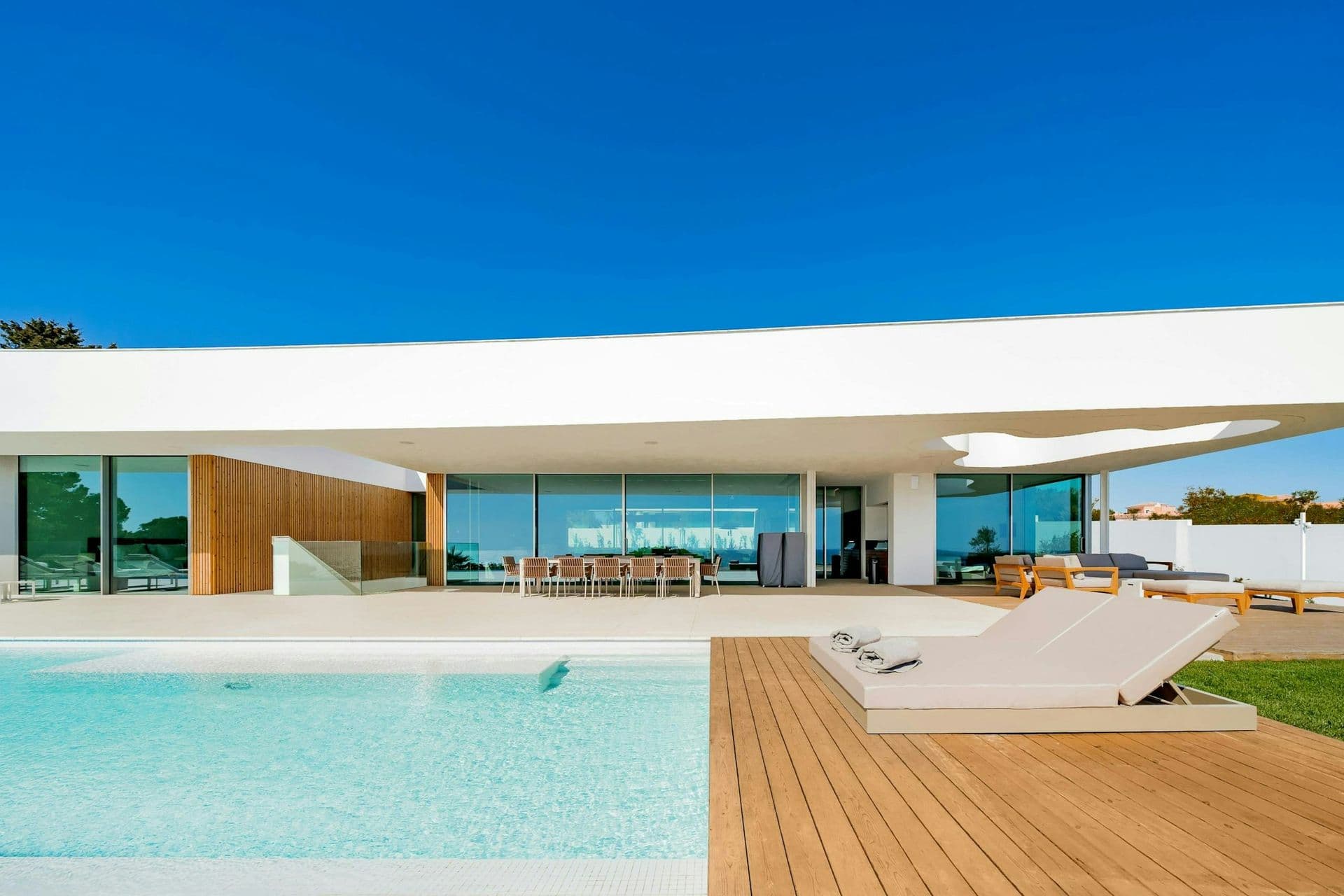Pool, timber deck and lawn beside the villa at A Coastal Crown, Lagos