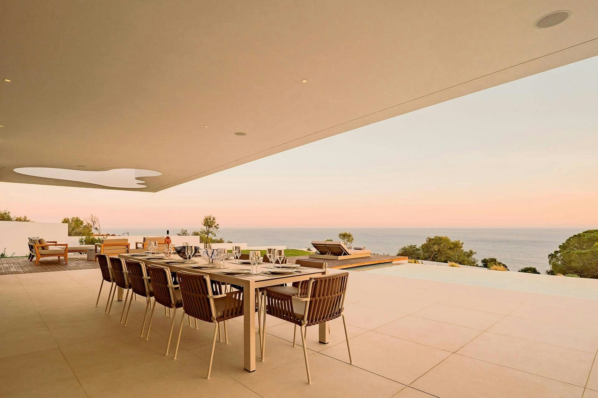 Outdoor dining table on the terrace at sunset over the sea at A Coastal Crown, Lagos