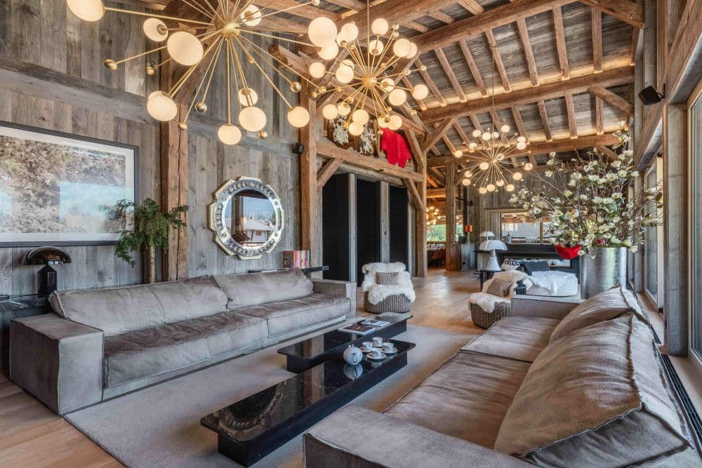Double-height barn living room with sculptural lighting and old timber at Megeve Centre 7