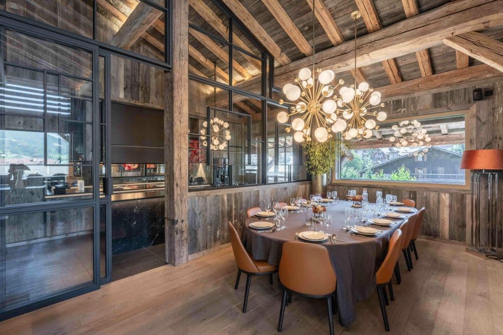 Dining room with a round table and sculptural chandelier at Megeve Centre 7
