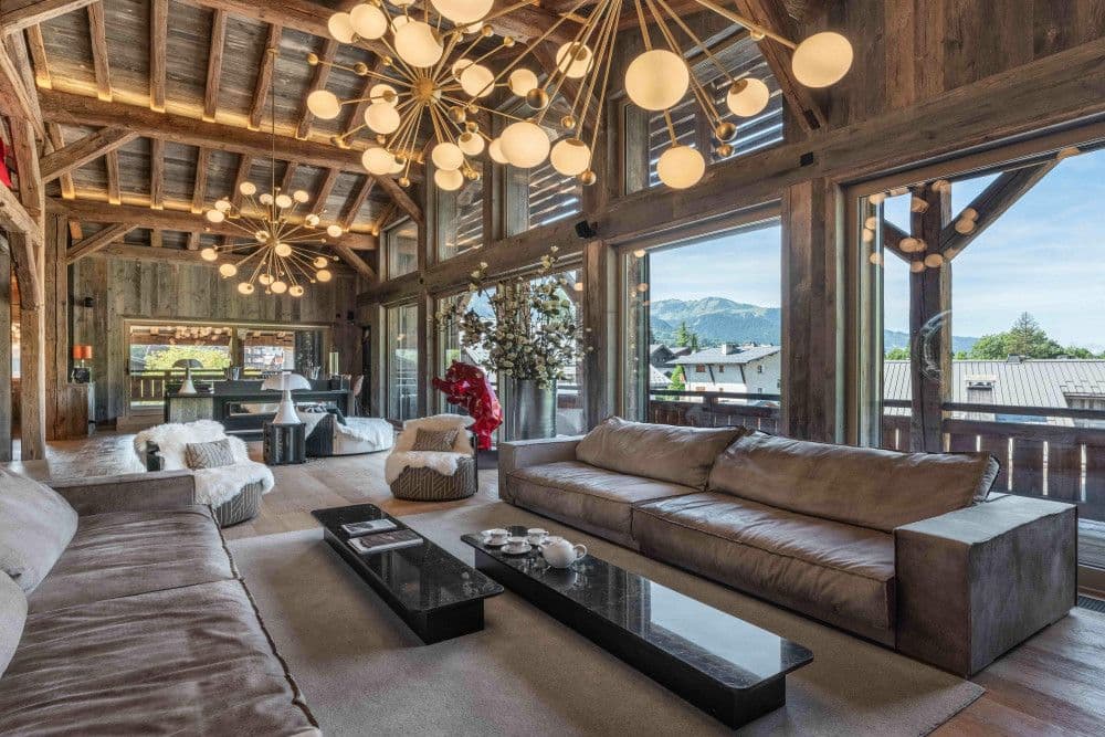 Living room with deep sofas opening to a mountain-view terrace at Megeve Centre 7