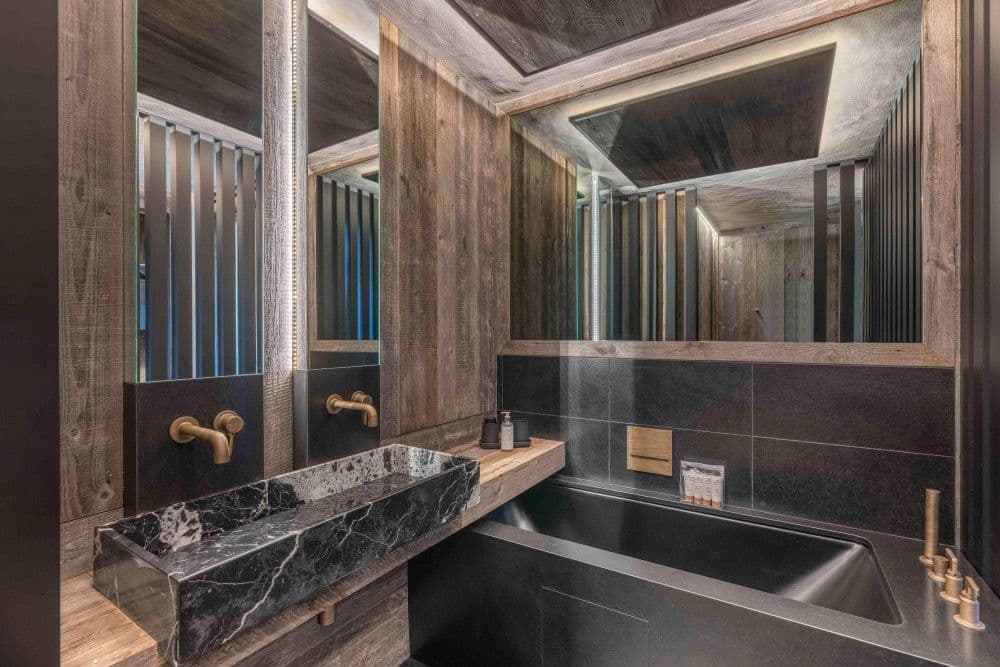 Marble bathroom with a double vanity and freestanding bath at Megeve Centre 7