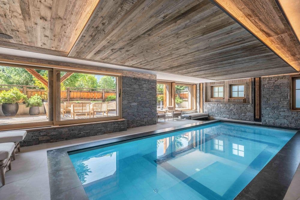Indoor pool with loungers opening to the terrace at Megeve Centre 7