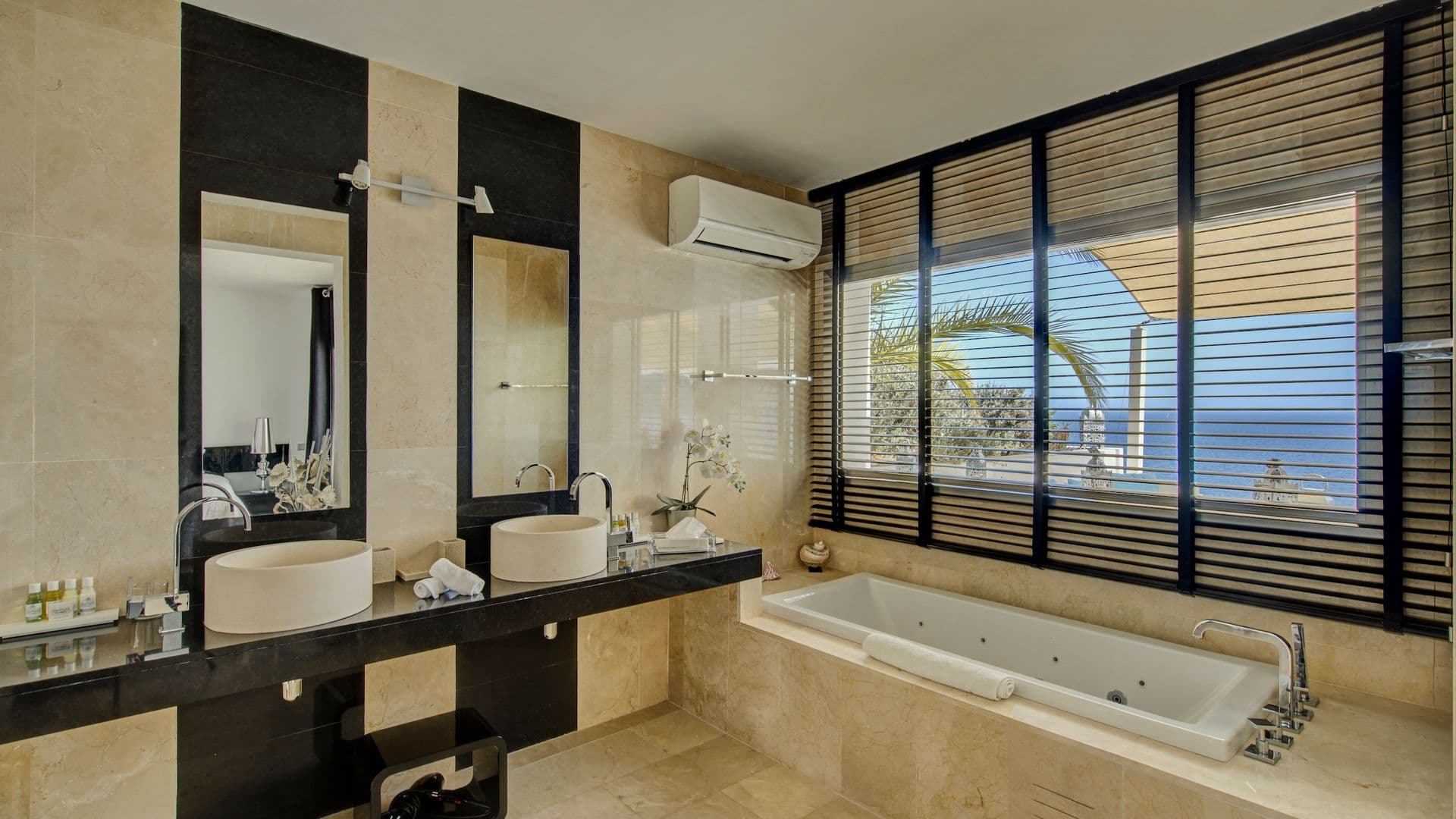 Bathroom with dark marble double vanity and freestanding tub